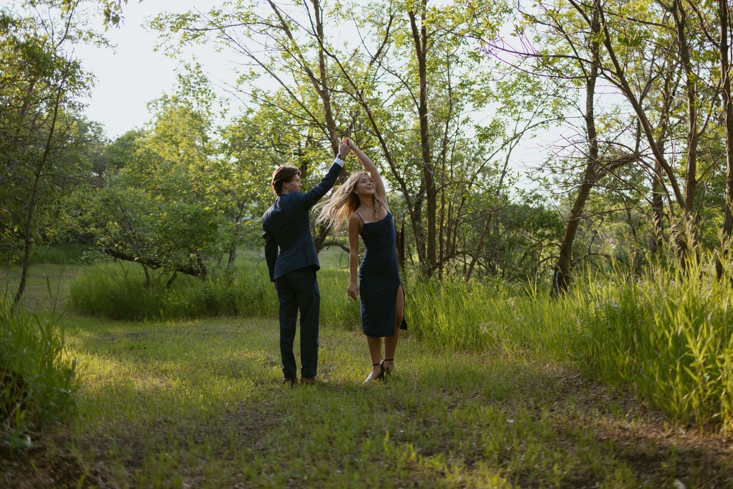 Group photoshoot in a scenic wooded area with natural lighting and green foliage.