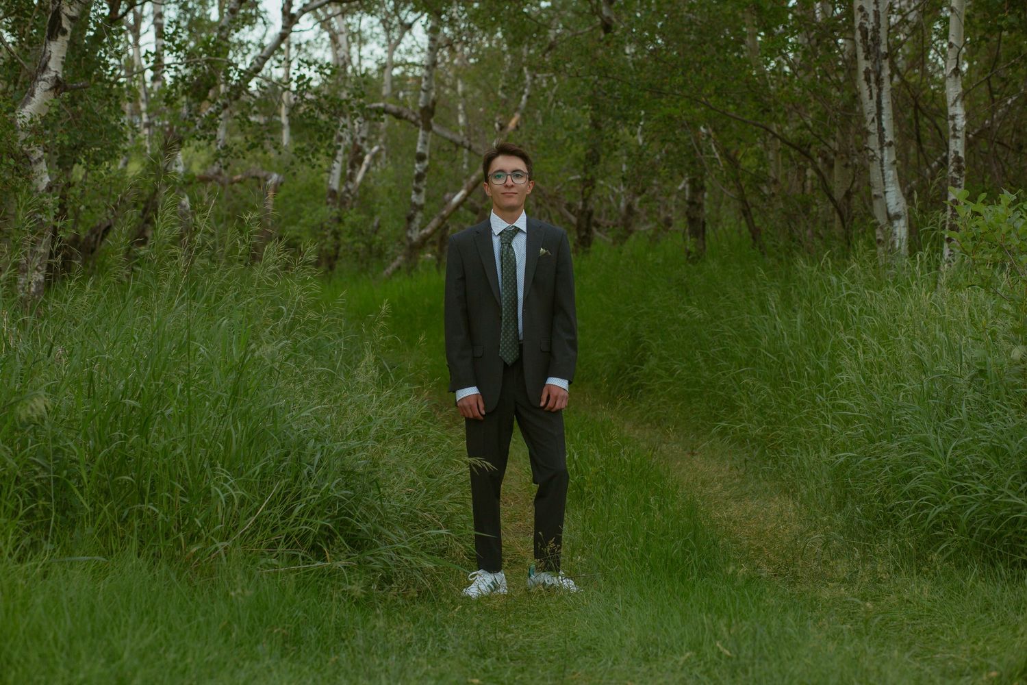 A formal photo session taking place in a lush green outdoor setting.