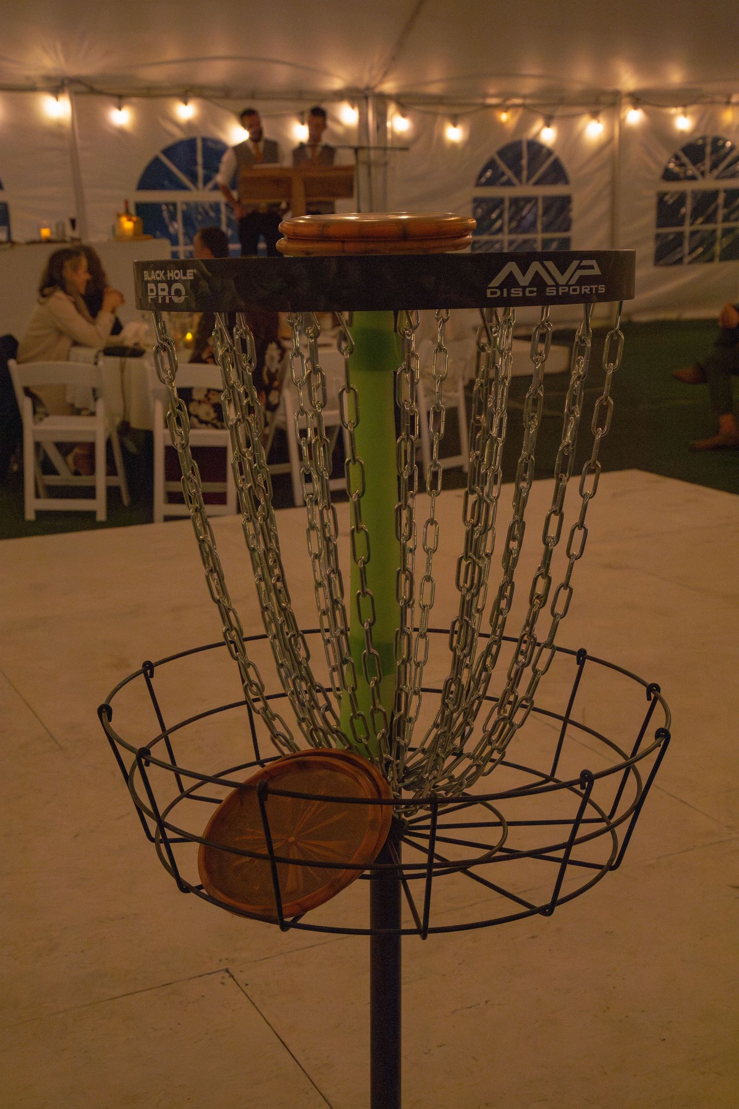 Metal candelabra stands with circular frames arranged in a row under tent lighting.