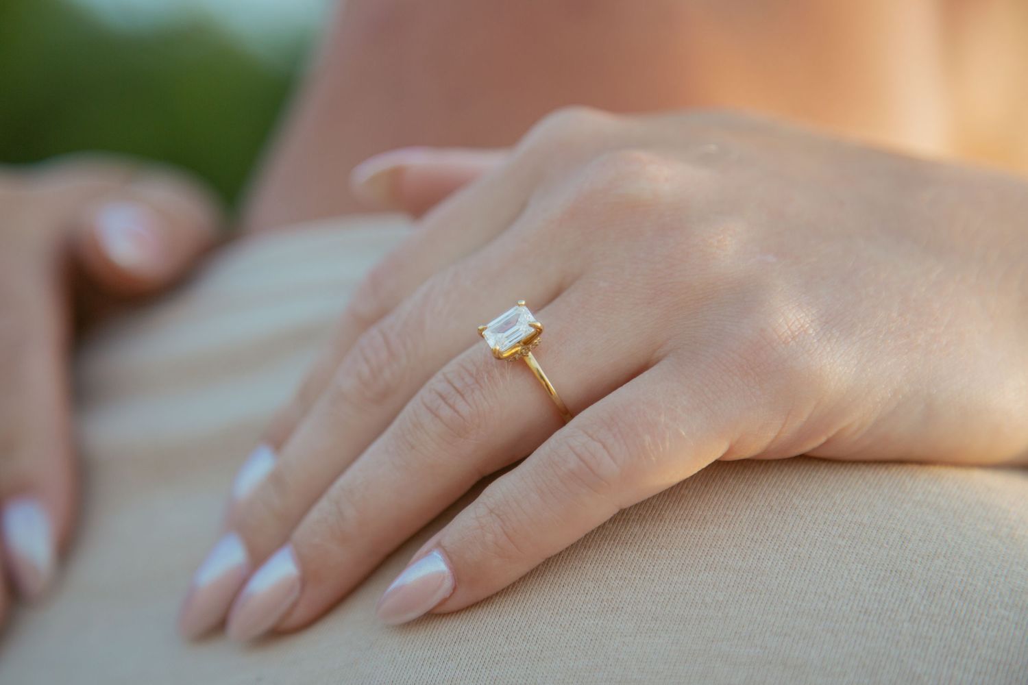 Close-up of an engagement ring on a woman's hand with soft natural lighting.