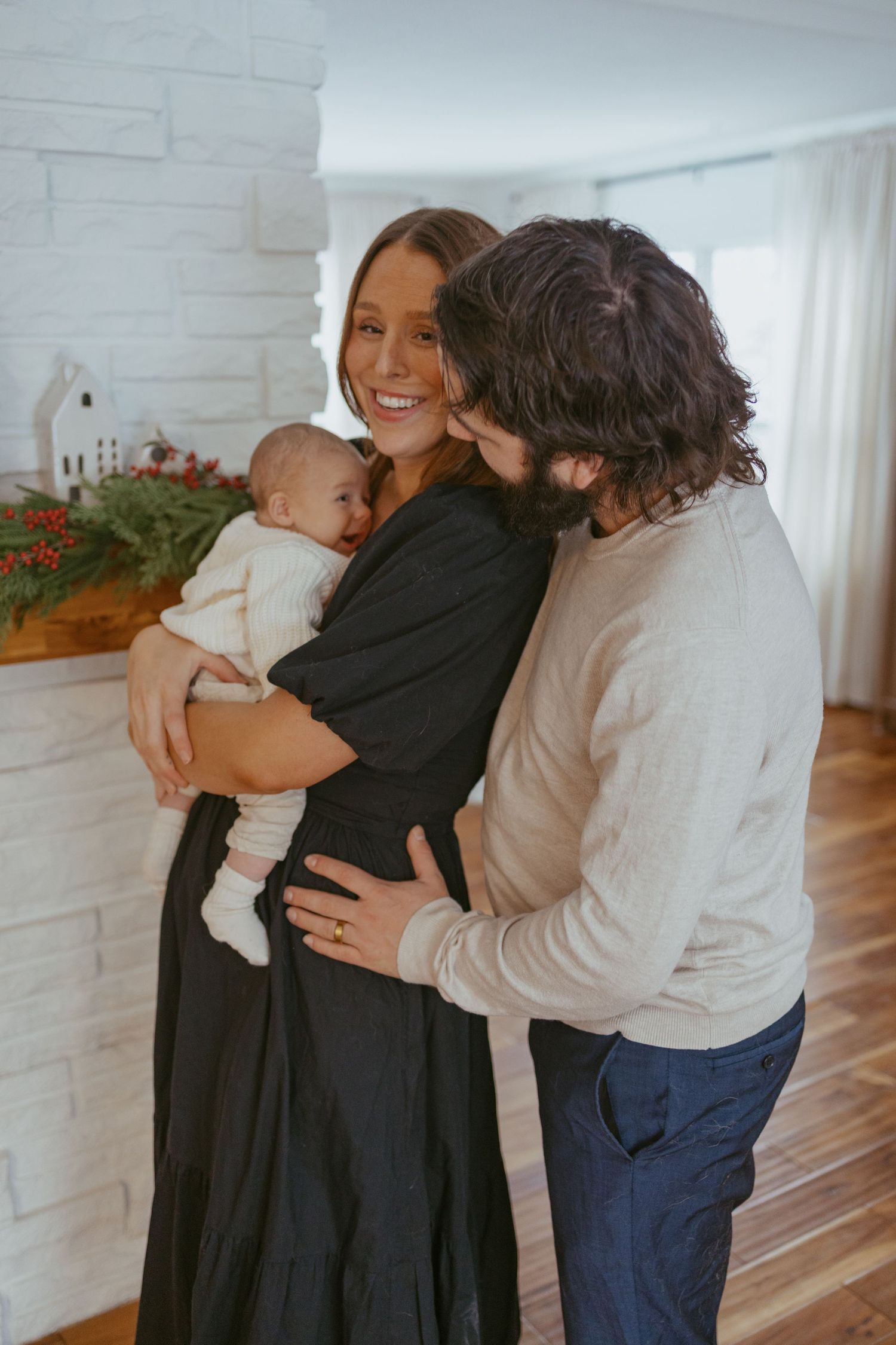 Family embracing and sharing tender moments in a bright modern kitchen space.