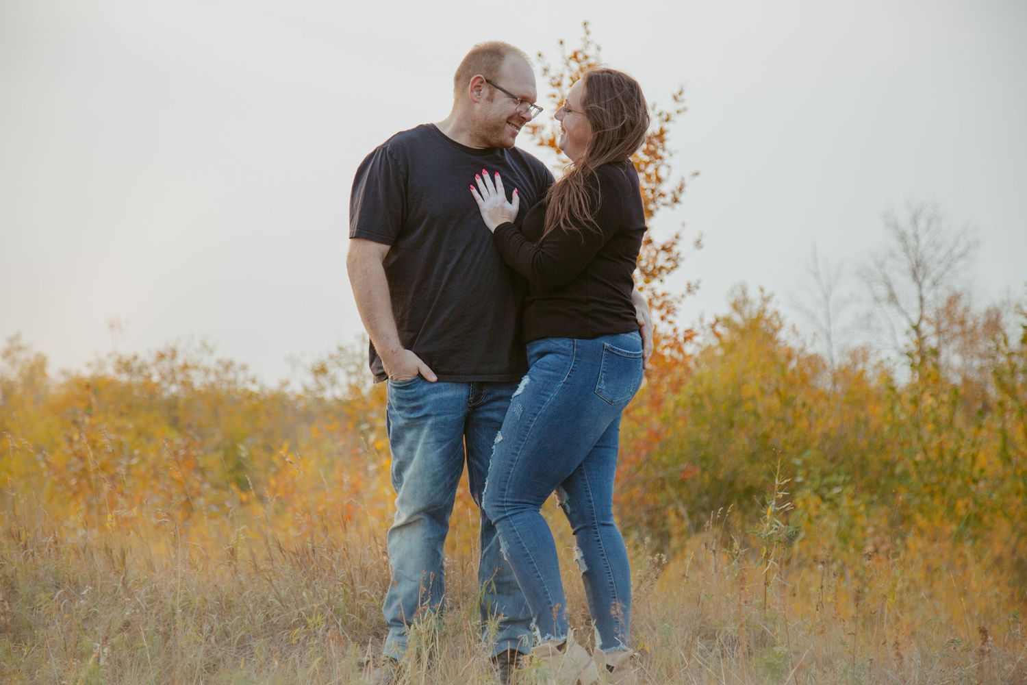 Romantic outdoor photoshoot in a field with fall foliage.