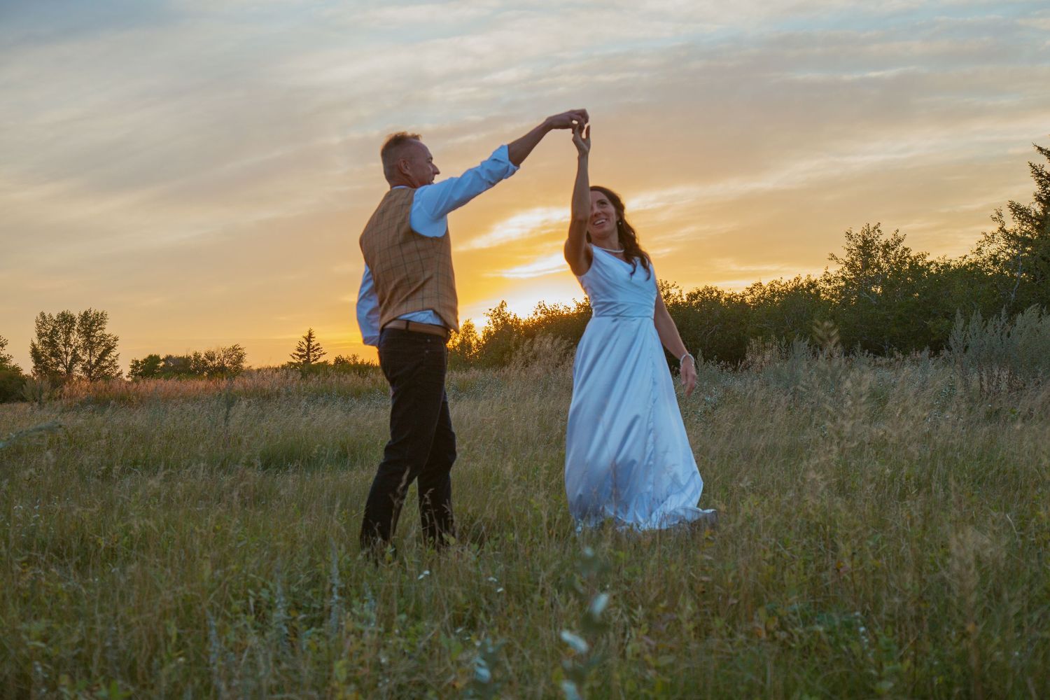 Couple shares intimate dance moves in a rustic outdoor setting at dusk.