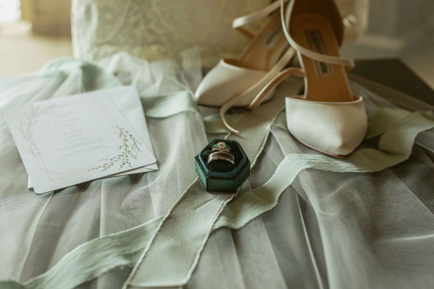 Wedding accessories including white shoes and dress fabric arranged on a light surface.