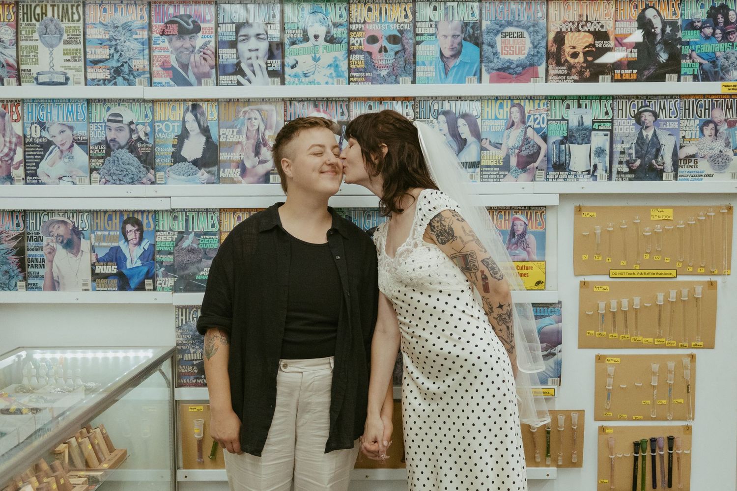 A couple browses through vinyl records at a record store with posters on the wall.