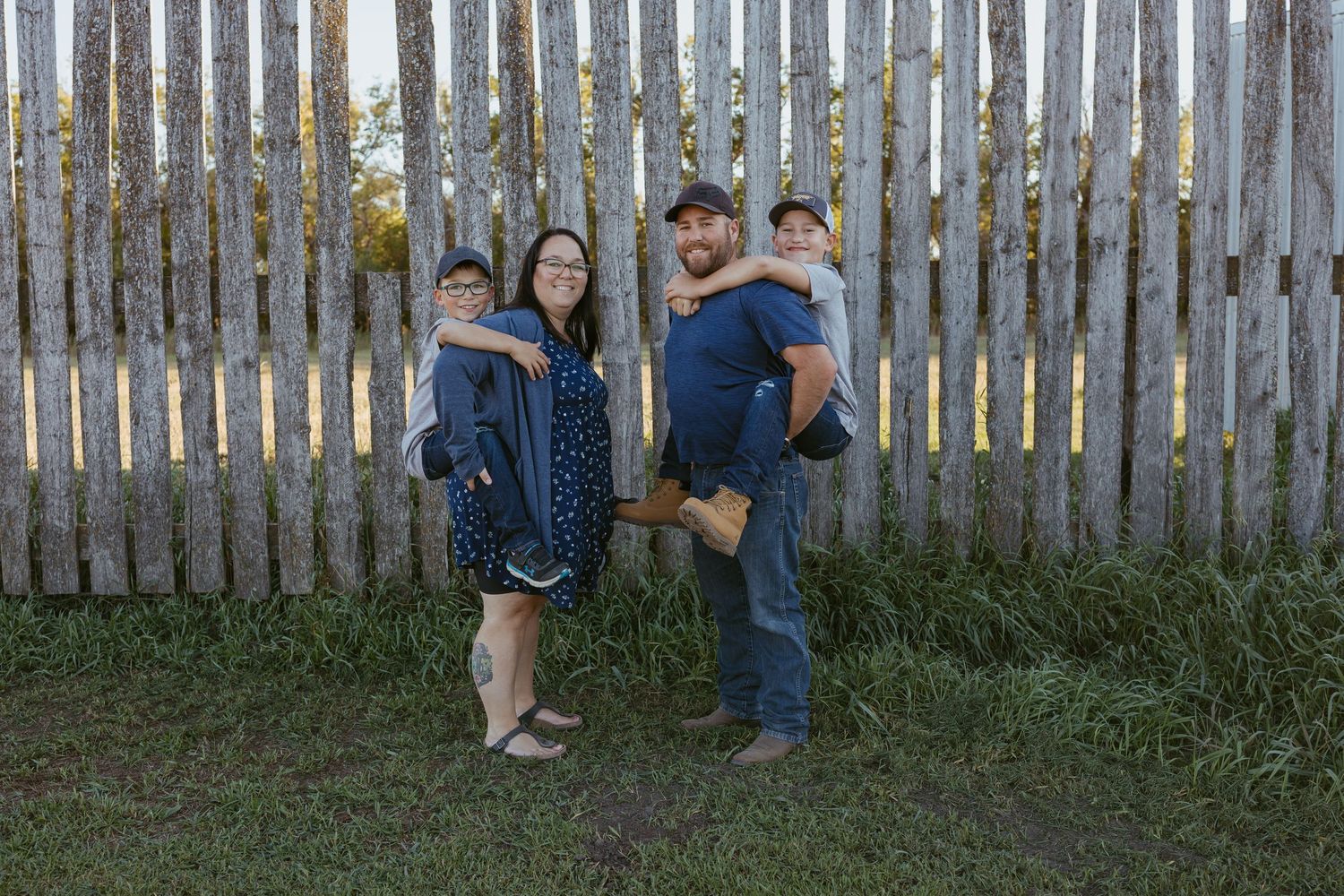 Rustic wooden fence creates backdrop for outdoor portrait session in garden setting.
