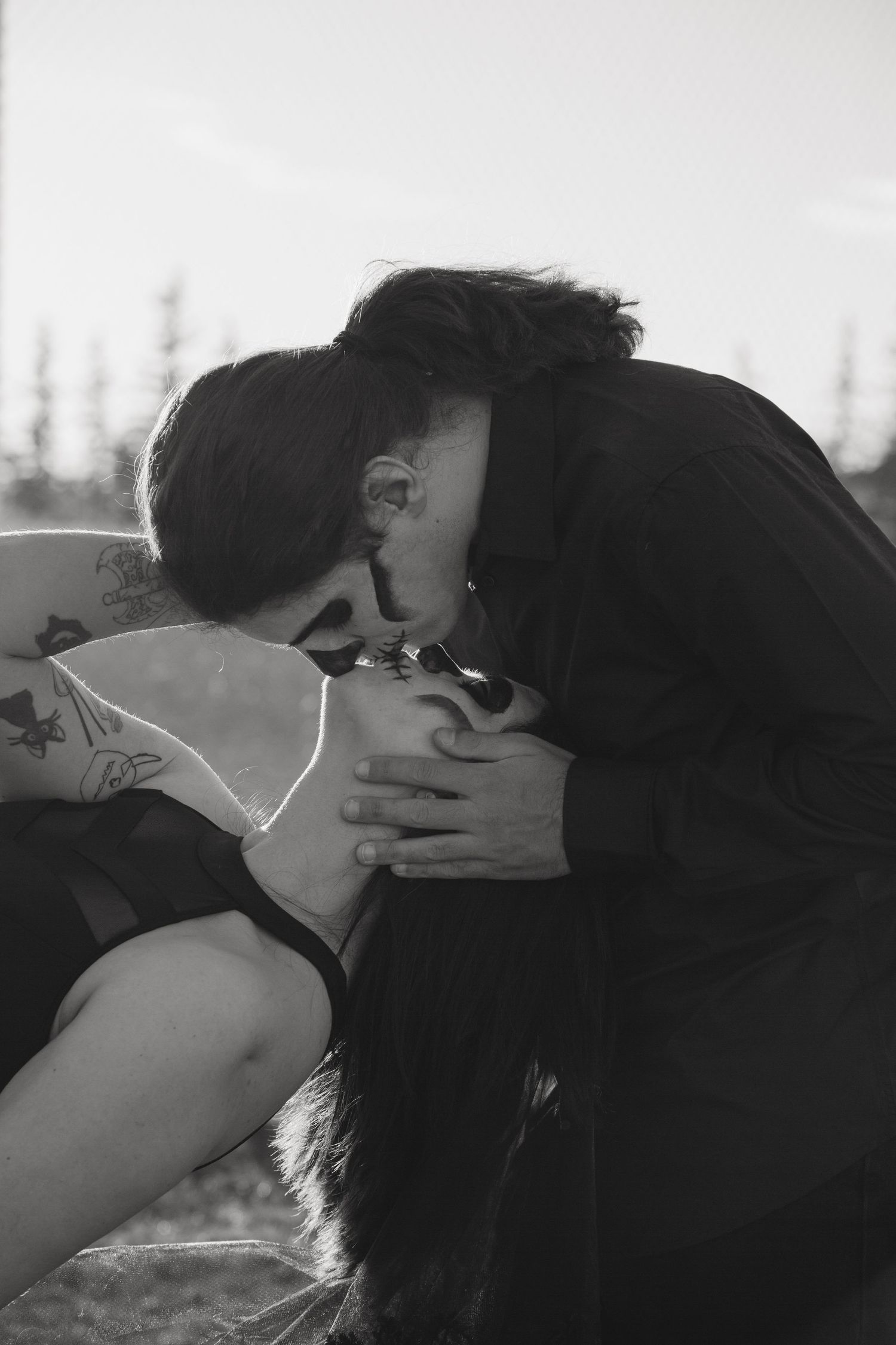 Intimate black and white portrait of a couple sharing a tender moment outdoors.