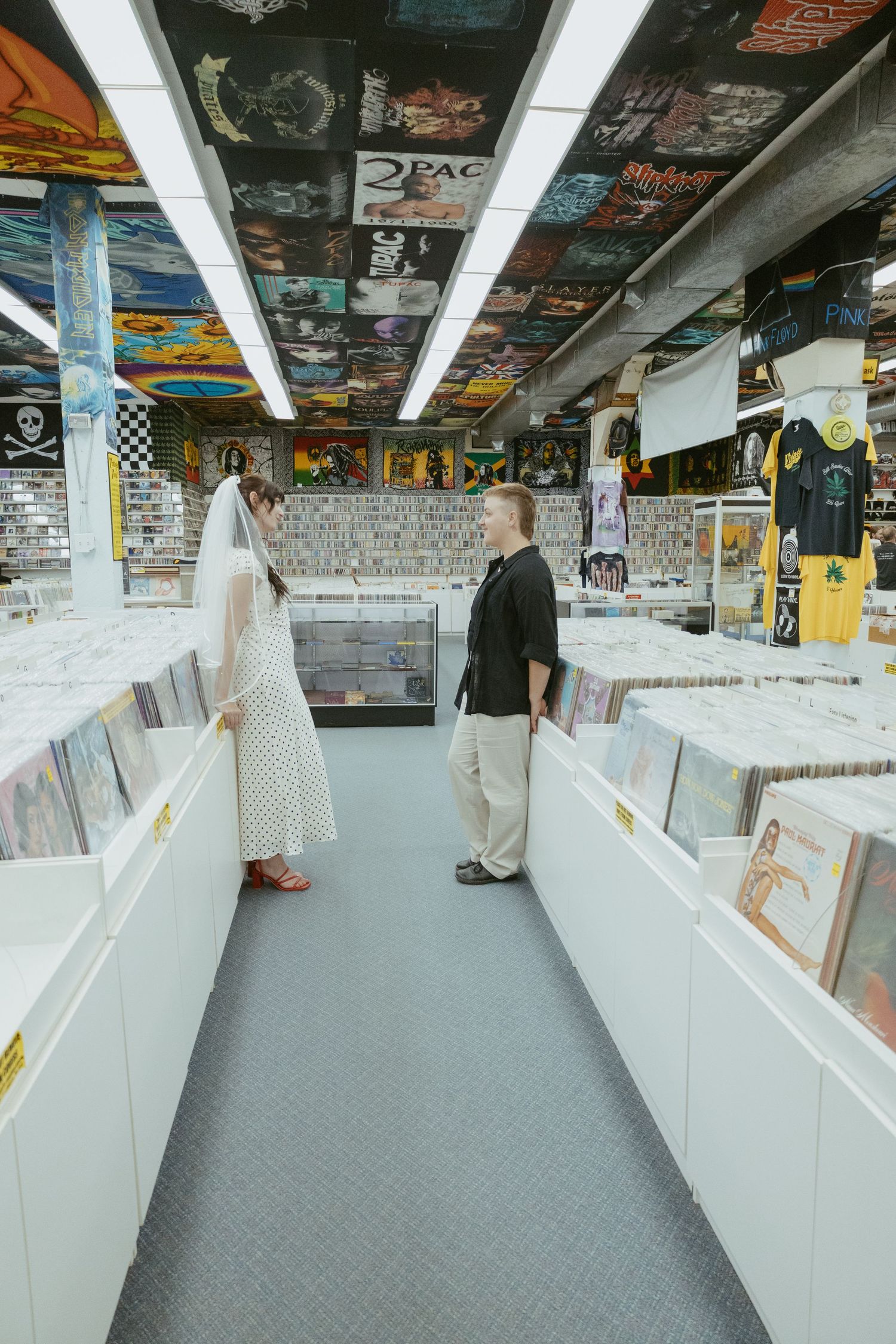 Wide angle view of a record store interior with white bins and decorated ceiling.