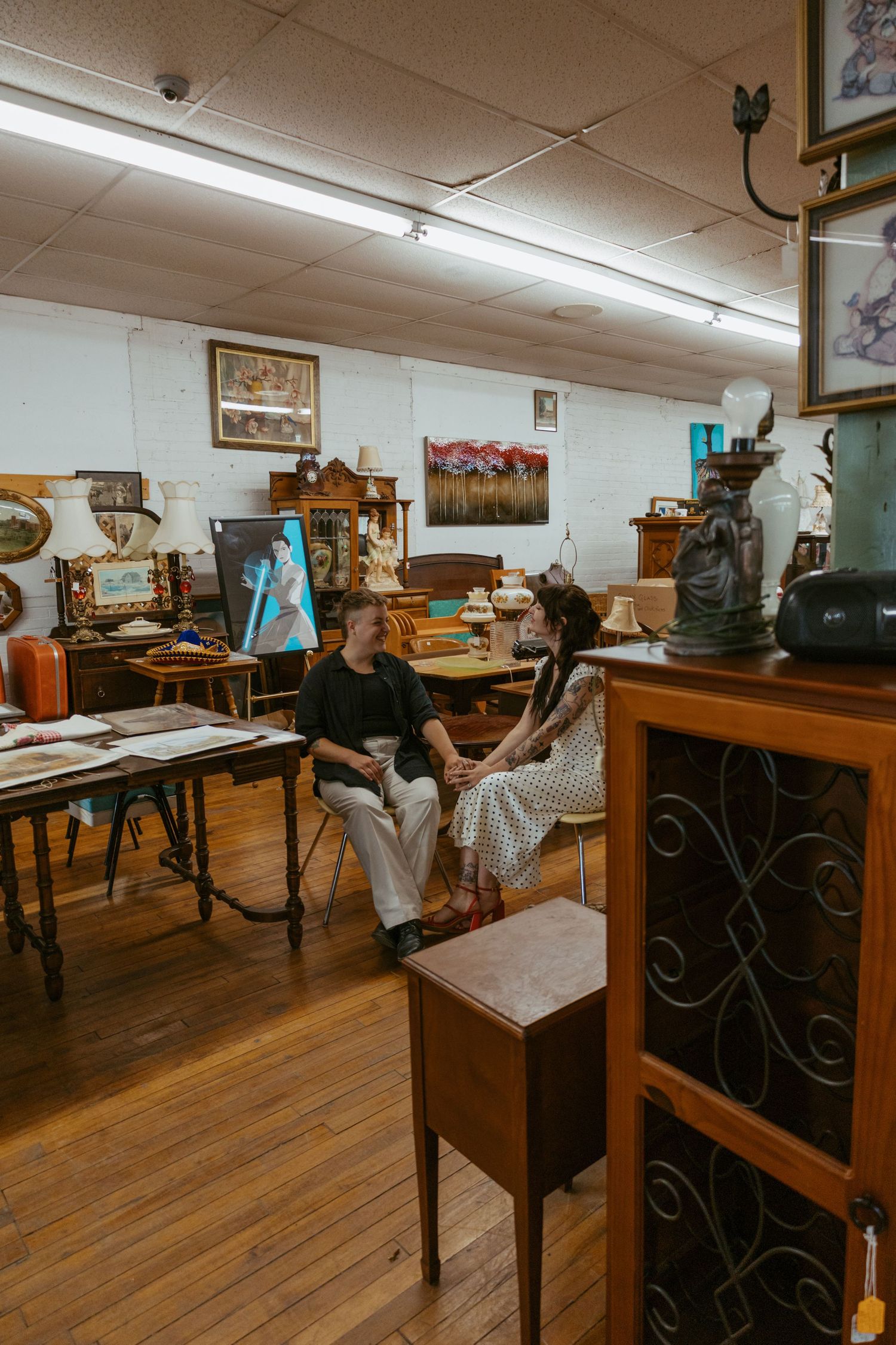 A room with vintage wooden furniture and hardwood floors under fluorescent lighting.