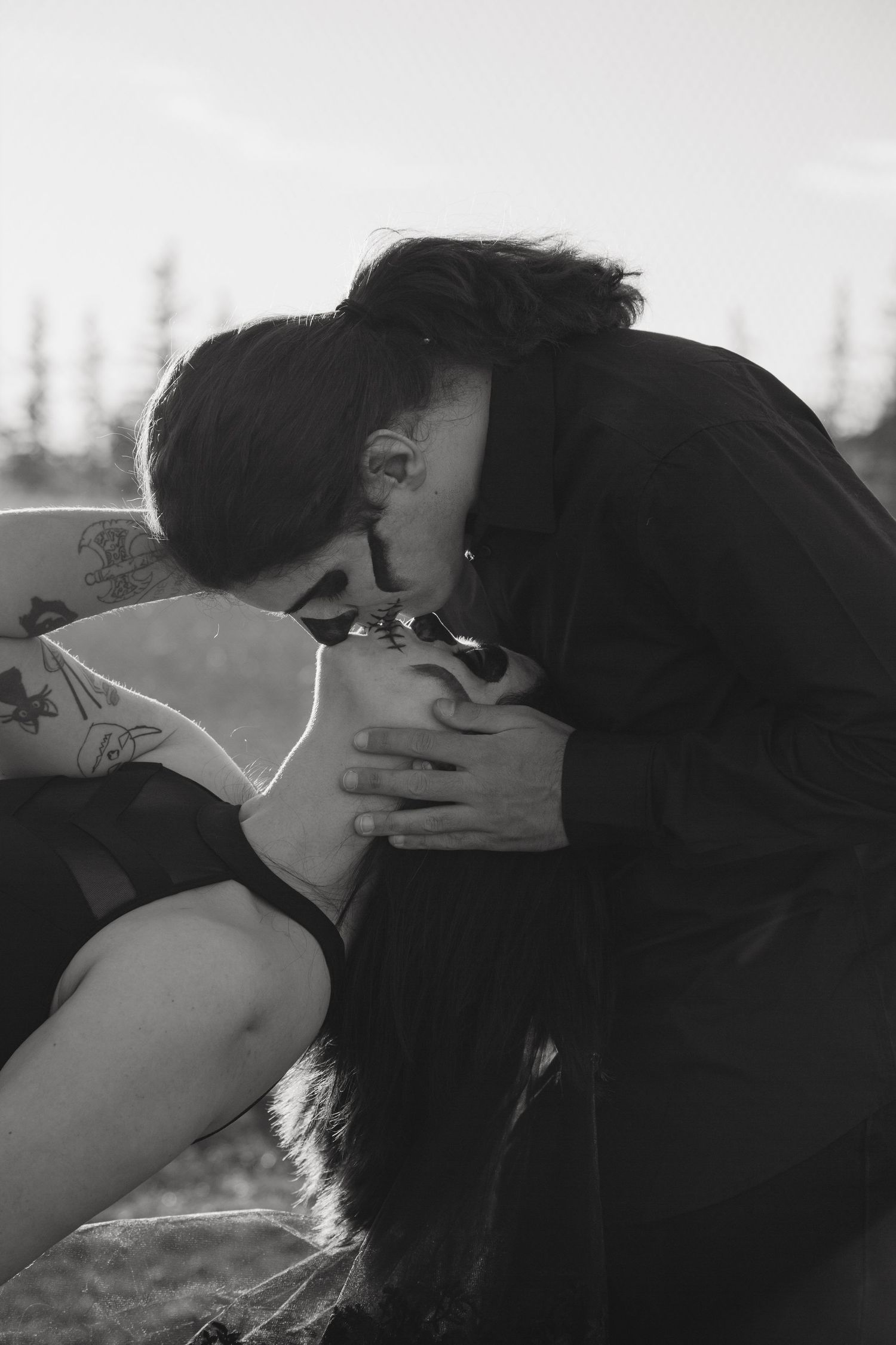 Intimate black and white portrait captured in outdoor setting at sunset.