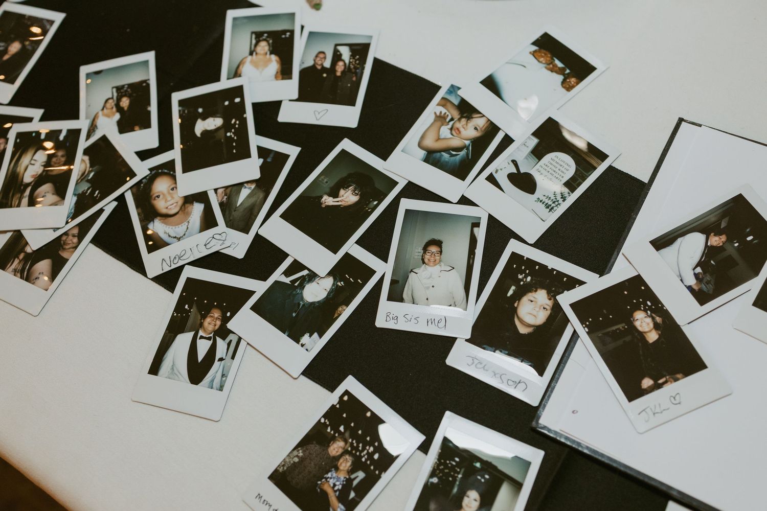 Collection of Polaroid instant photos scattered on a white table capturing candid party moments and portraits.