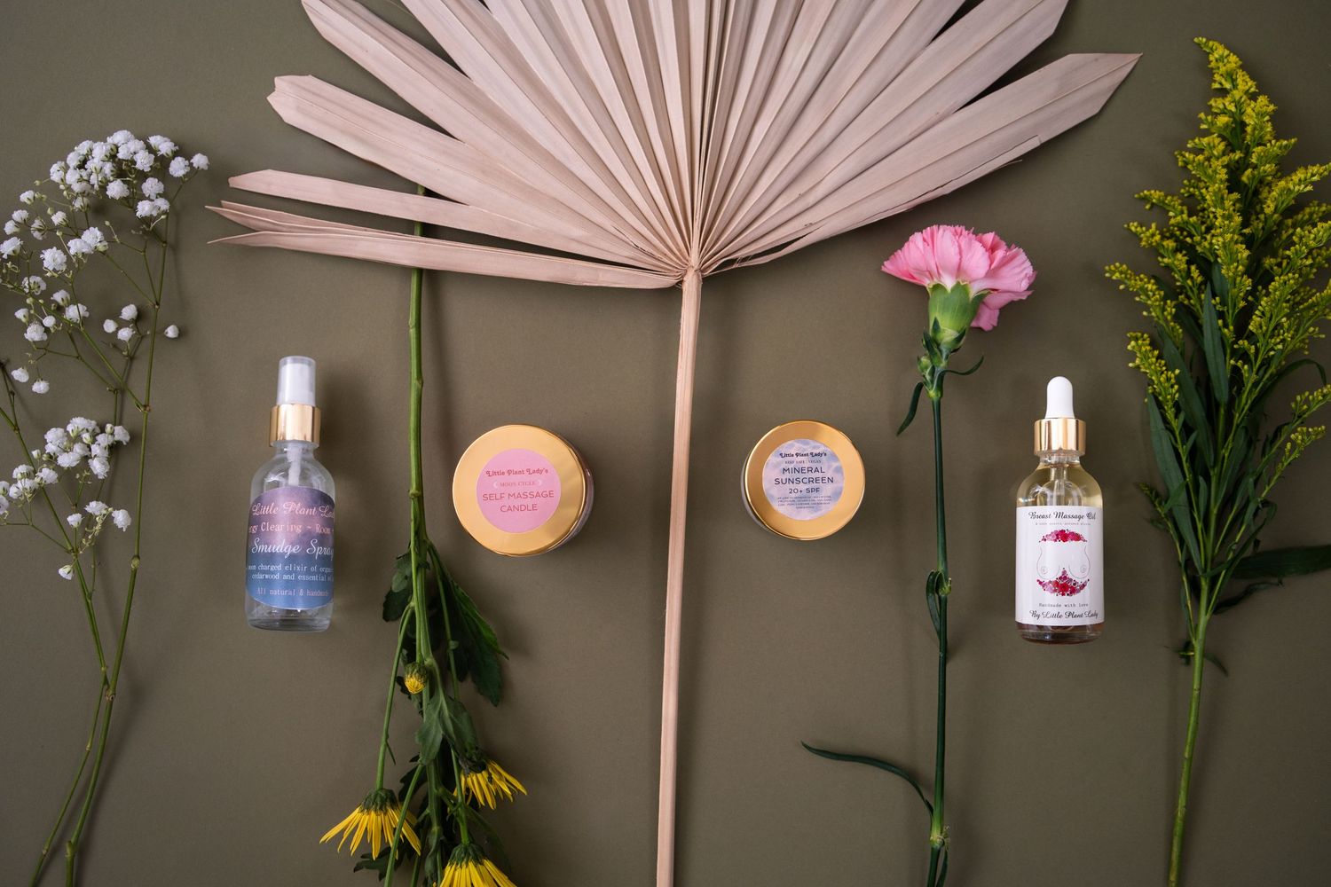 Pink paper fans and delicate floral arrangements create a romantic wedding decor display against a gray wall.