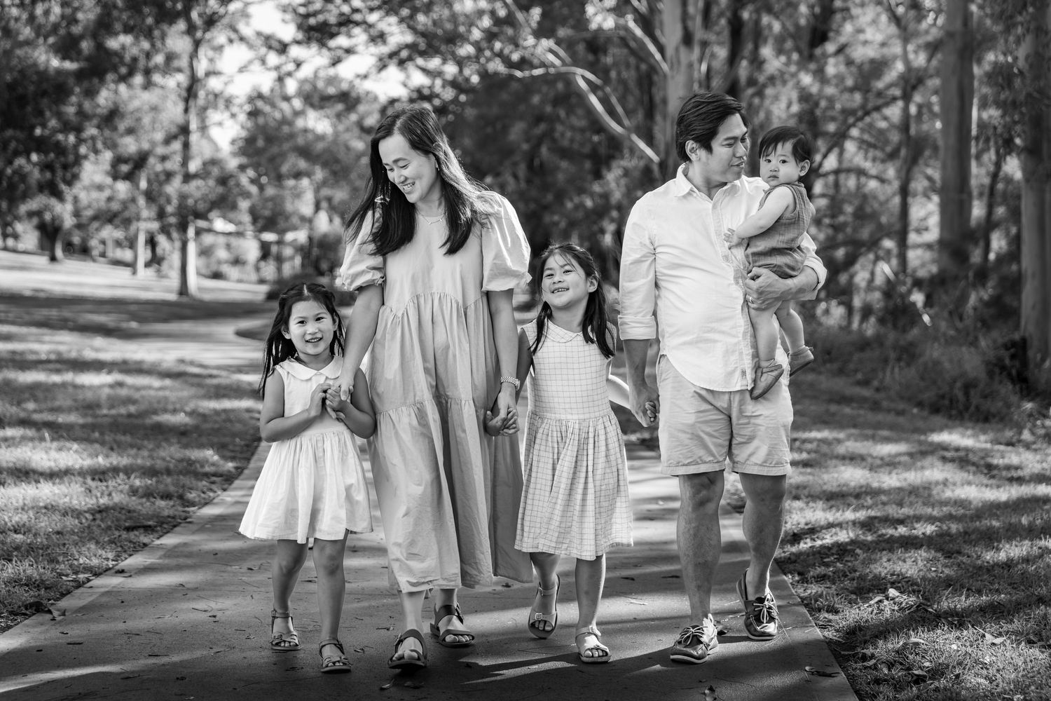 Group walking together on a tree-lined path during sunny afternoon.