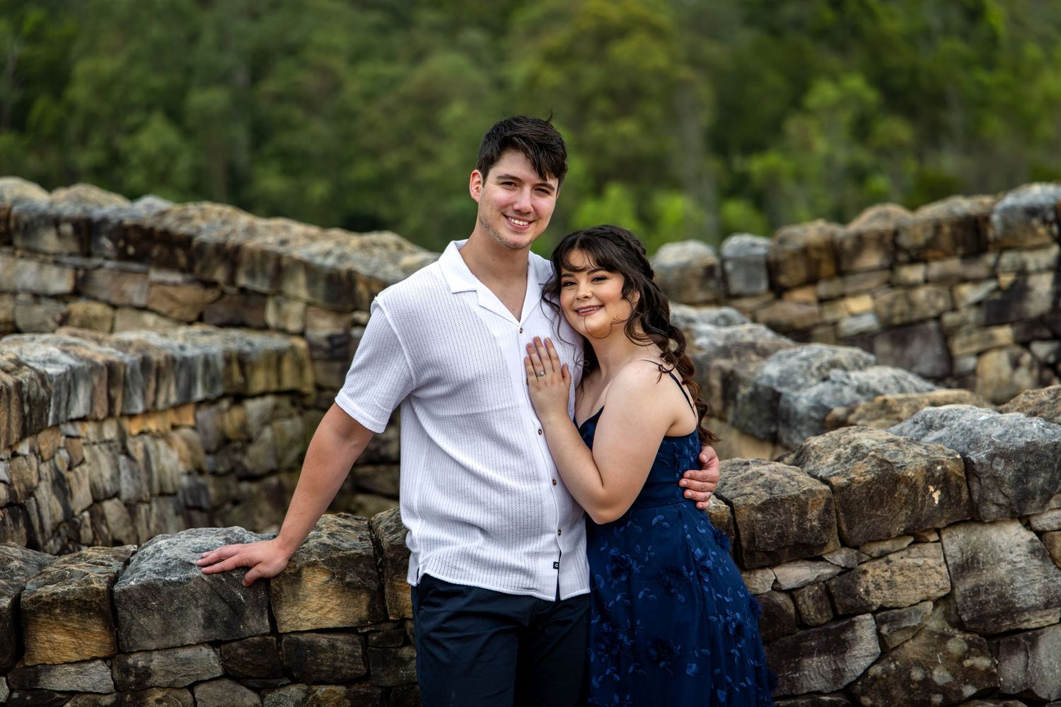 Couple sitting together on the Wedding Knot stone wall at Mount Anna Botanical Gardens.