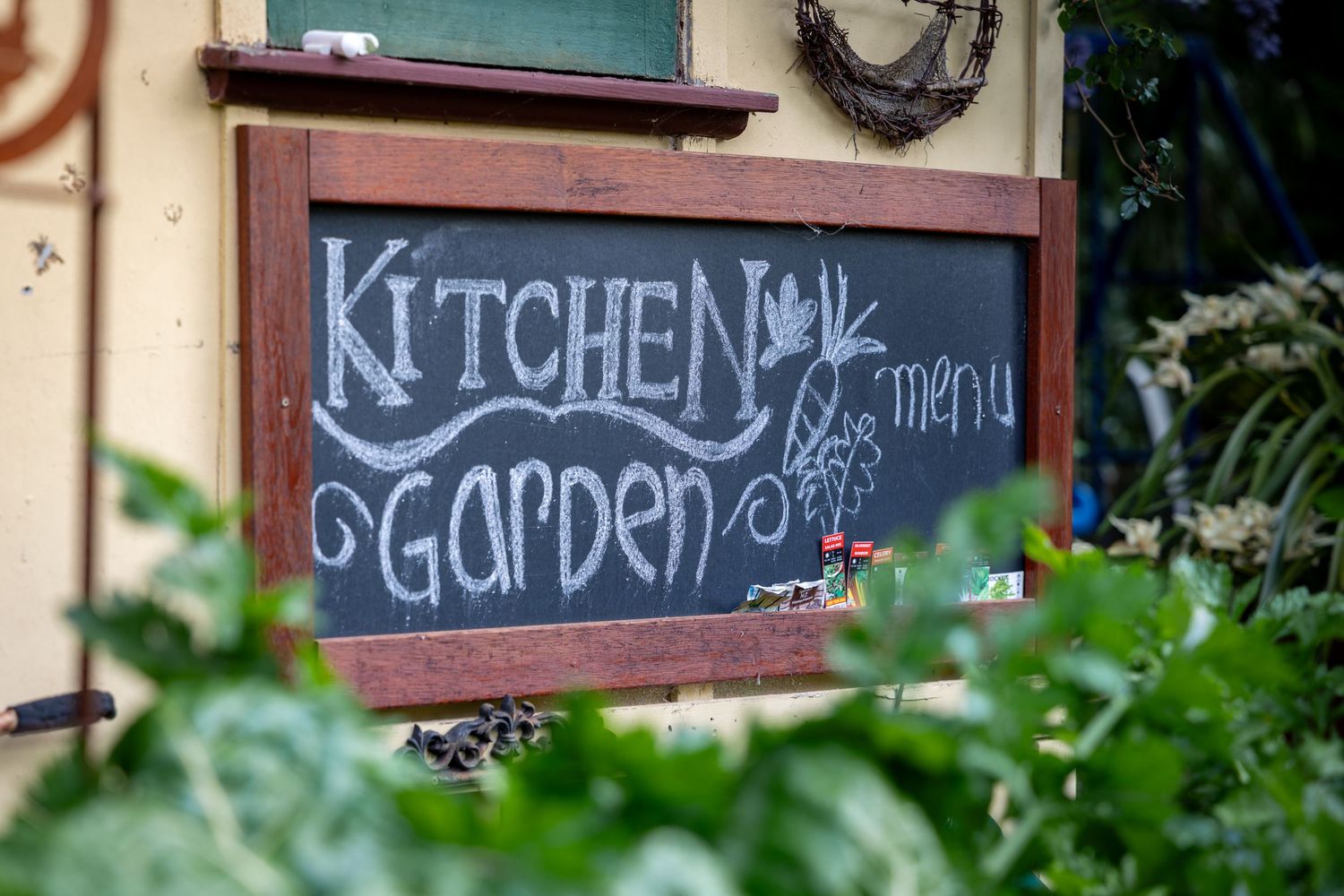Rustic chalkboard signs with kitchen and garden text hanging on weathered wooden wall in Springwood, Blue Mountains.