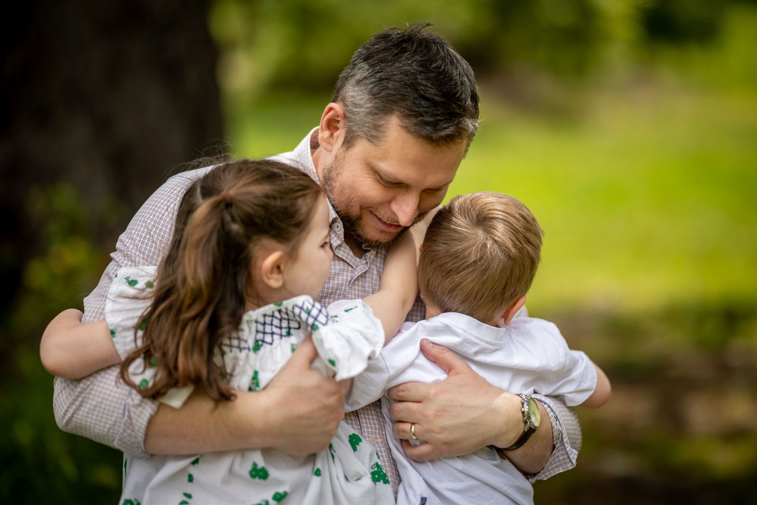 Intimate family embrace captured in sunlit outdoor setting at Woodford Reserve in the Blue Mountains.