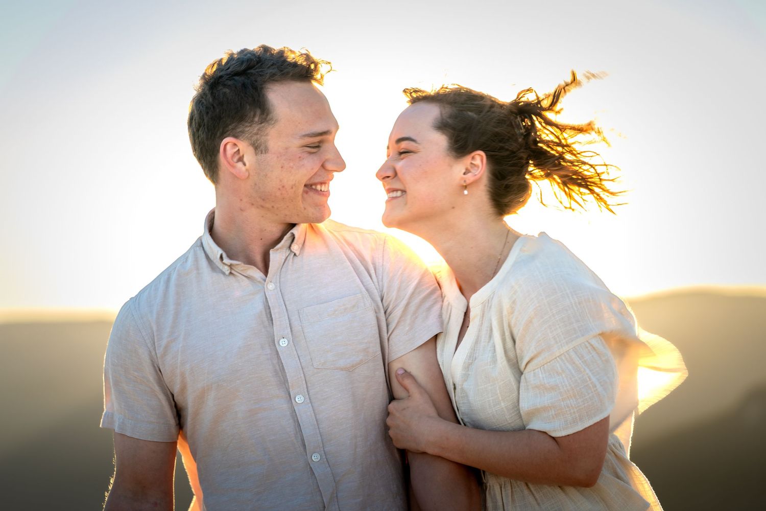 Couple shares romantic moment at sunset with dramatic lighting and scenic views at Lincoln's Rock in Wentworth Falls, Blue Mountains.
