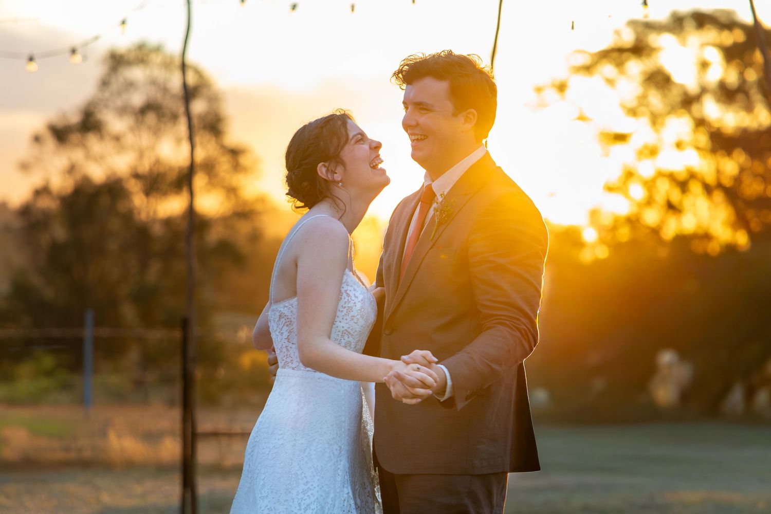 Wedding couple dancing together during golden hour with sun setting in background in Singleton, Blue Mountains.