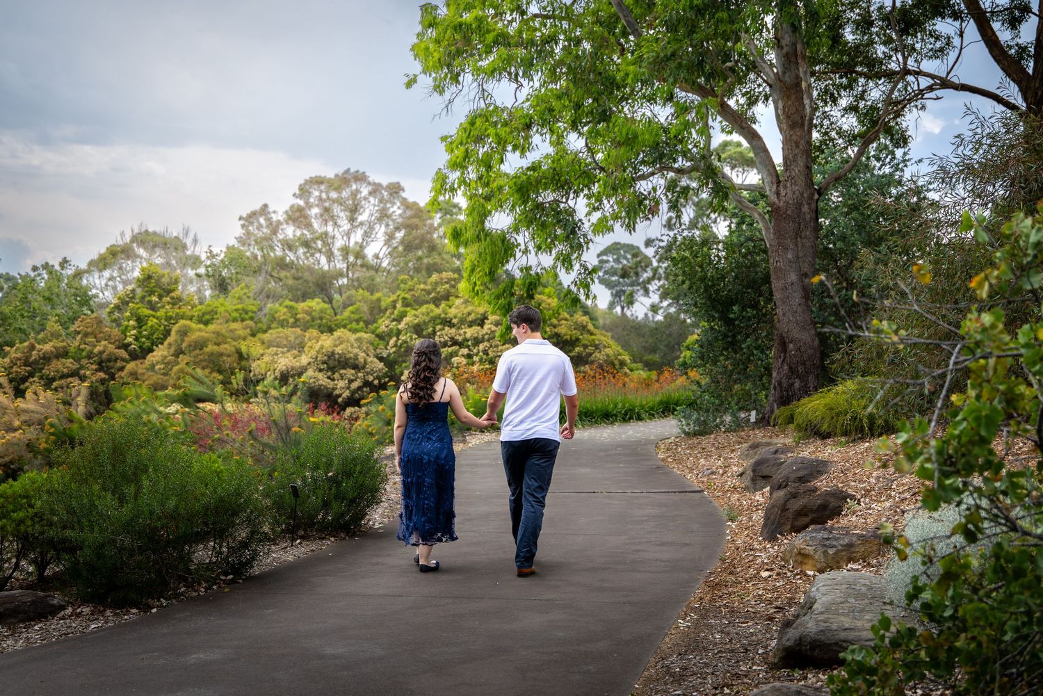 Couple strolling along a winding path in a scenic park at Mount Anna Botanic Gardens