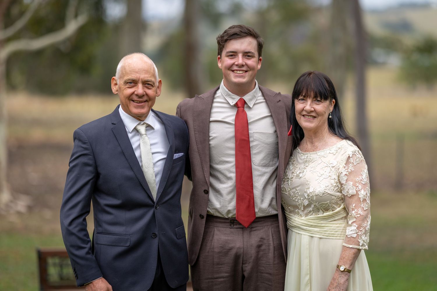 Wedding groom and his parents posing together in a natural outdoor setting in Singleton, Hunter Valley.