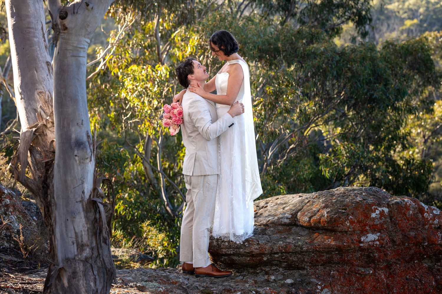 Couple embracing in outdoor bush wedding setting at Maya Sanctuary.