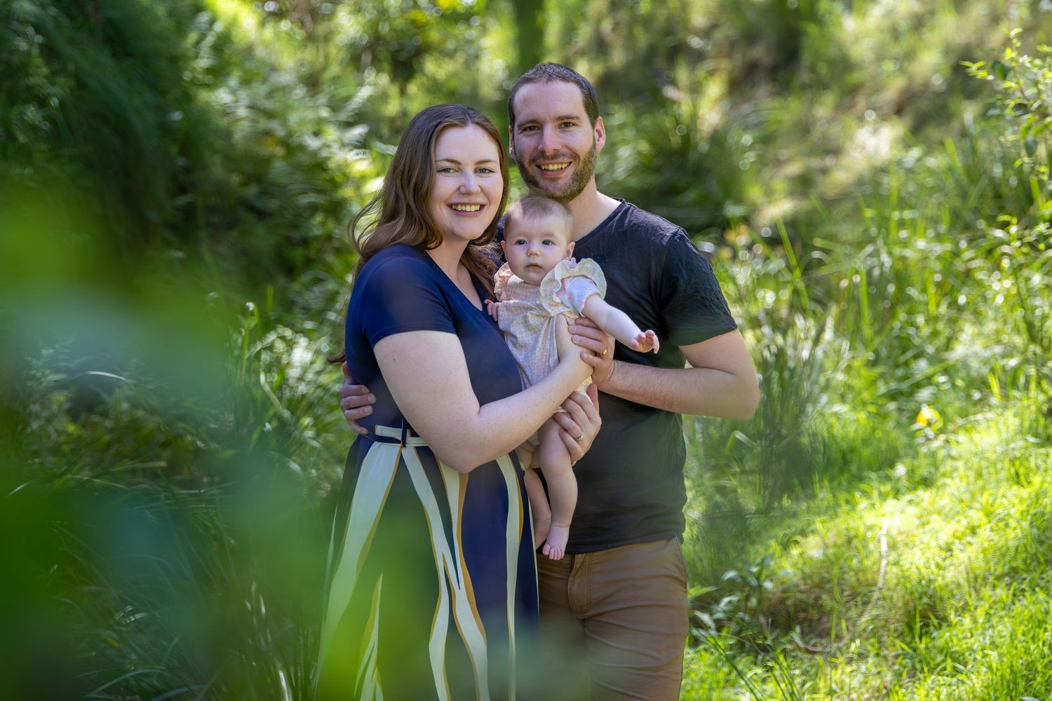 Couple sharing tender moment in sunlit garden setting at Euroka Clearing, Glenbrook in the Blue Mountains.