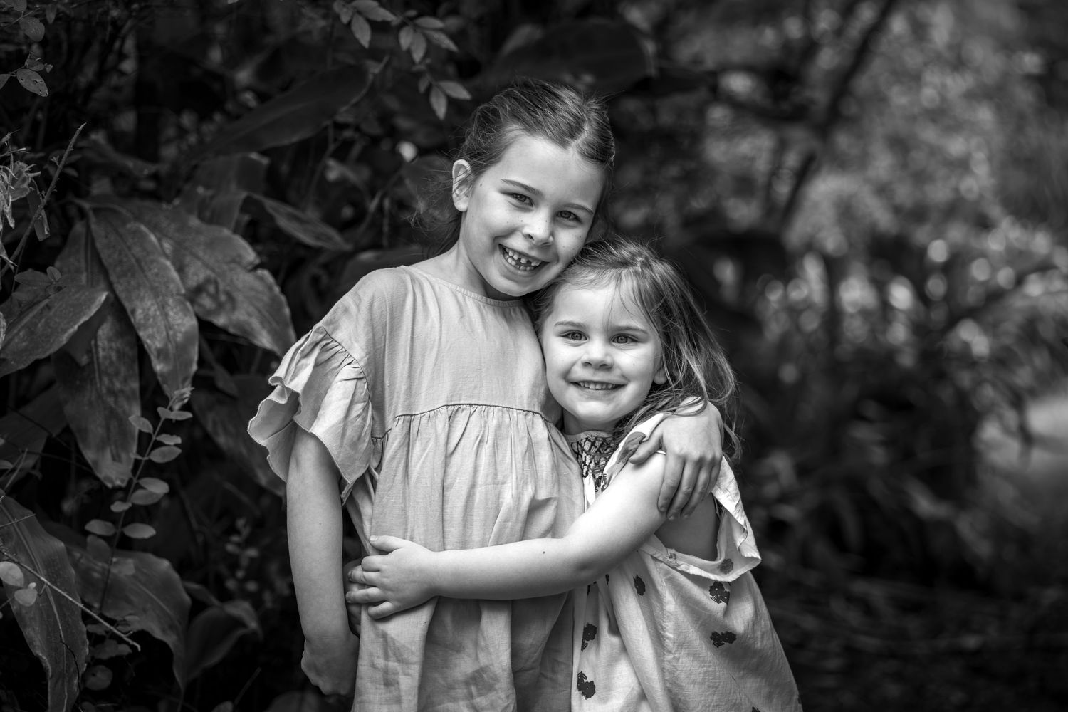 Black and white portrait of siblings sharing a sweet moment outdoors at Woodford Reserve in the Blue Mountains.
