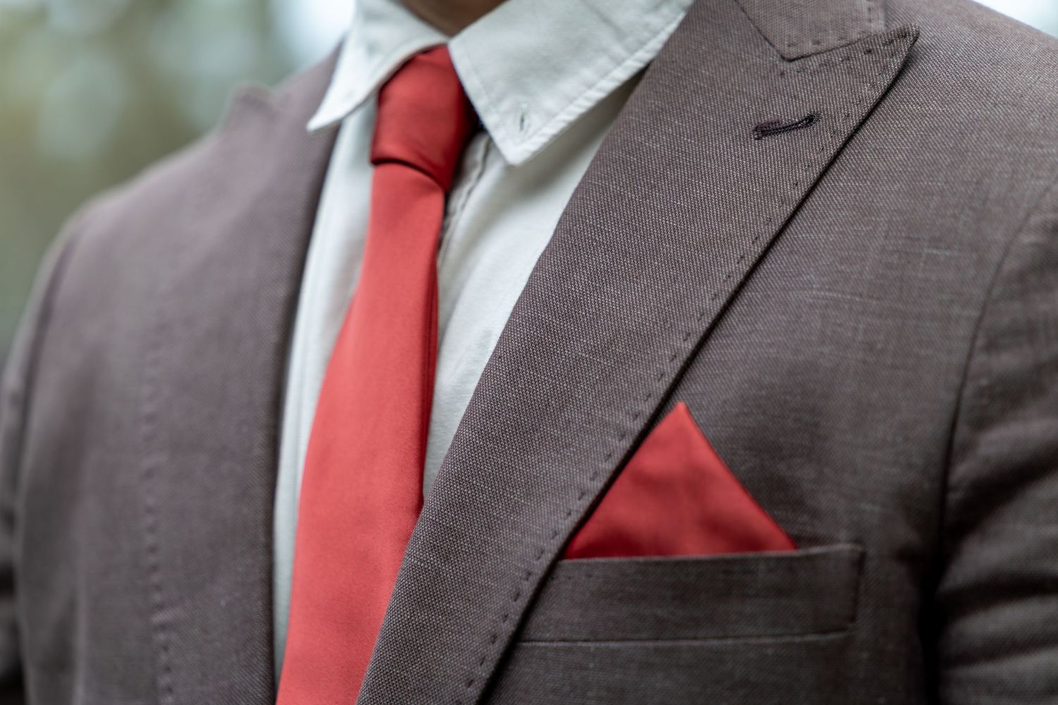Professional headshots showing details of a brown suit jacket with red tie and pocket square in Singleton, Hunter Valley.