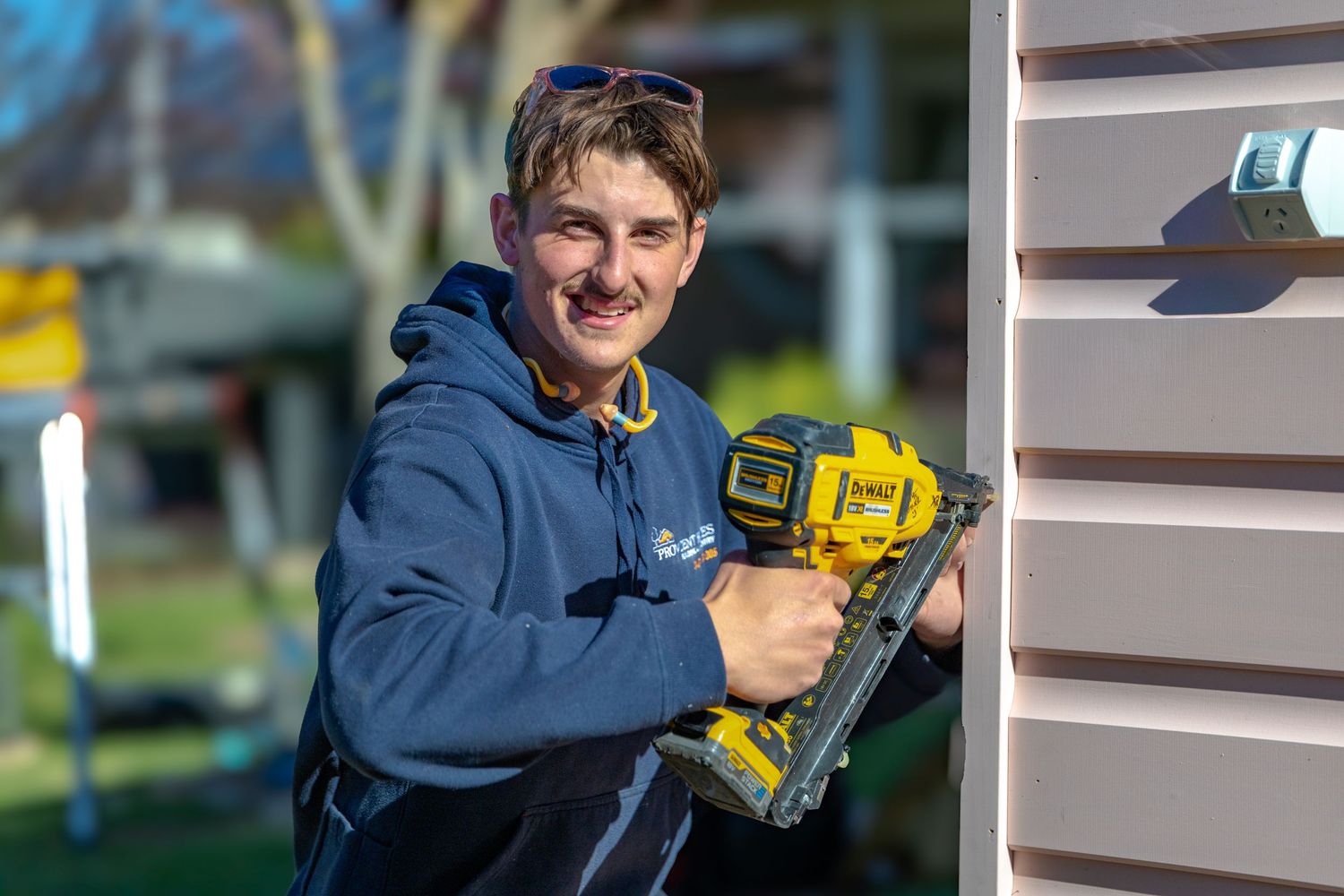 Young, handsome man using power tools and construction equipment while working on home repairs.