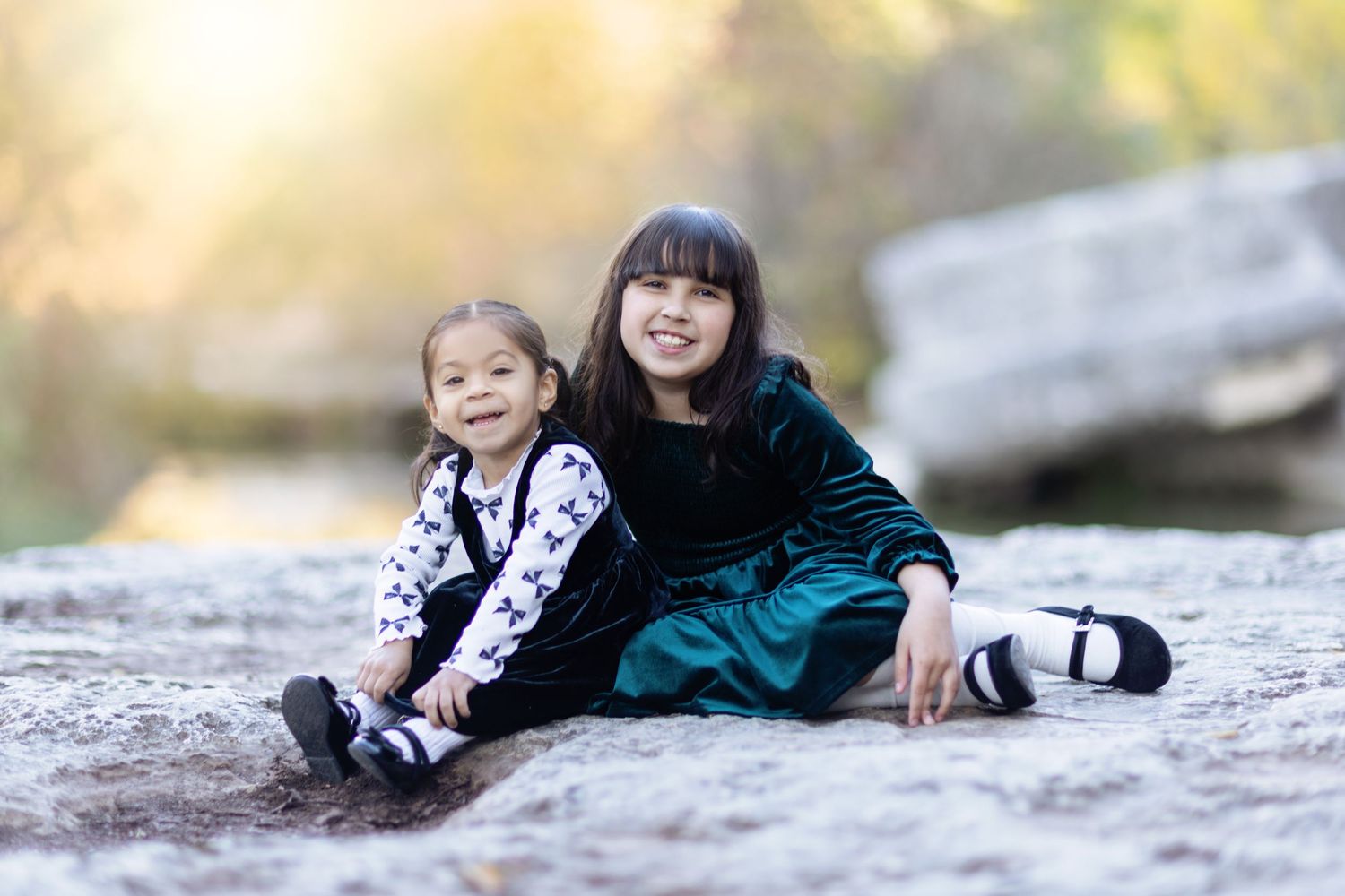 People lie together on textured rocks during an outdoor portrait session.