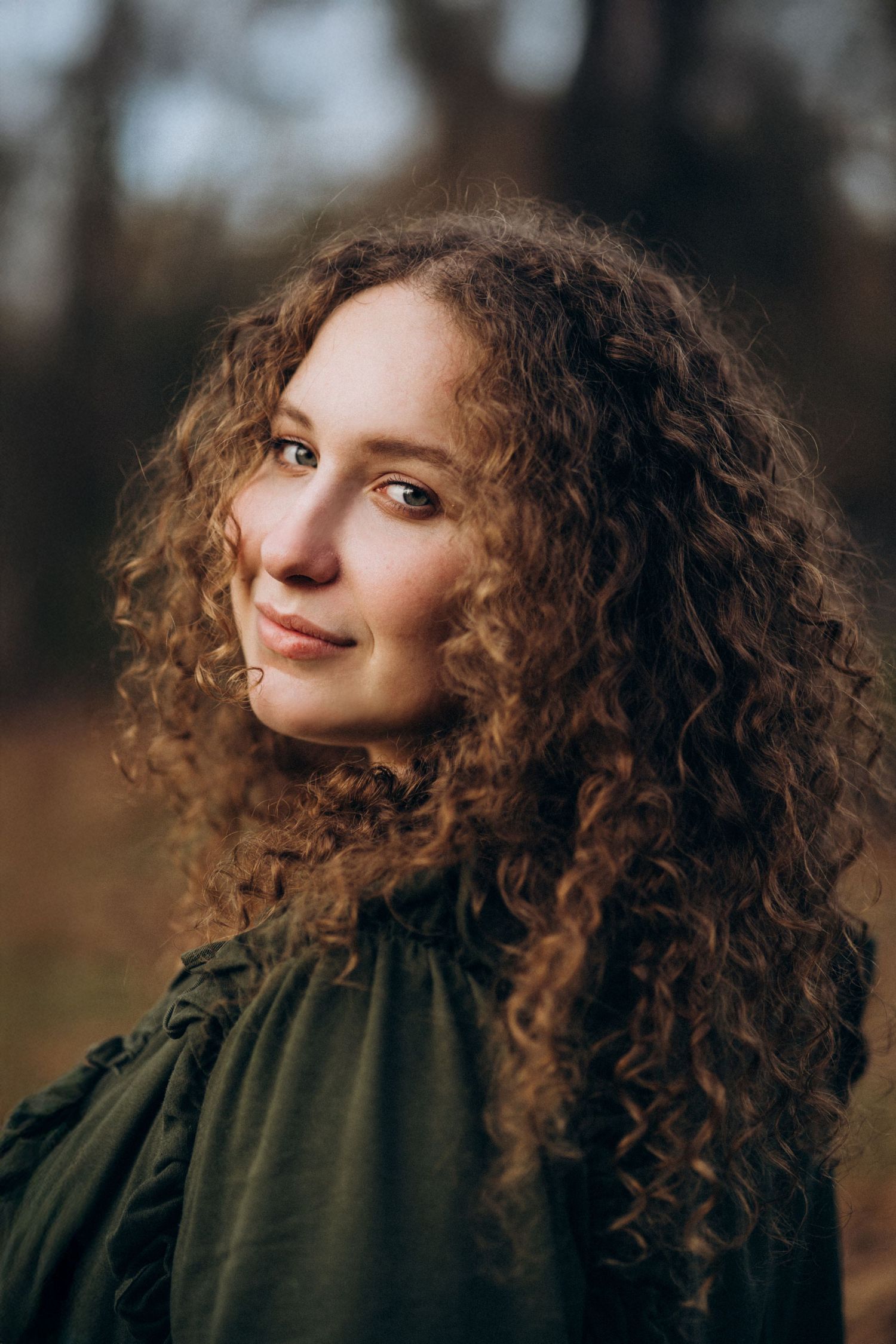 Artistic portrait series featuring curly hair and olive green sweater against autumn backdrop.