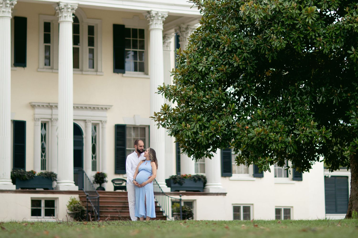 Classic white columned building exterior with manicured landscaping and stone details.