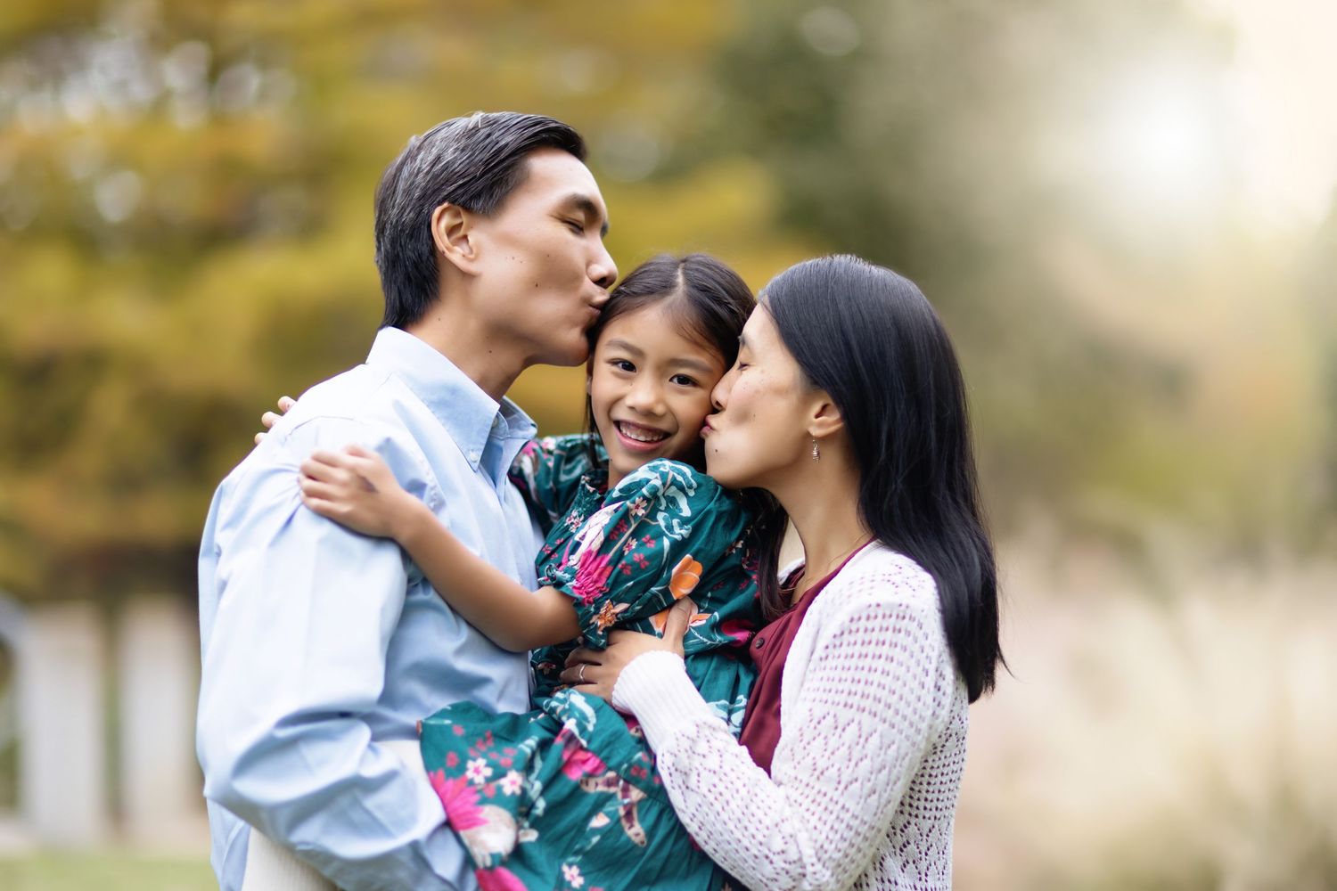 A loving family moment captured outdoors during autumn.