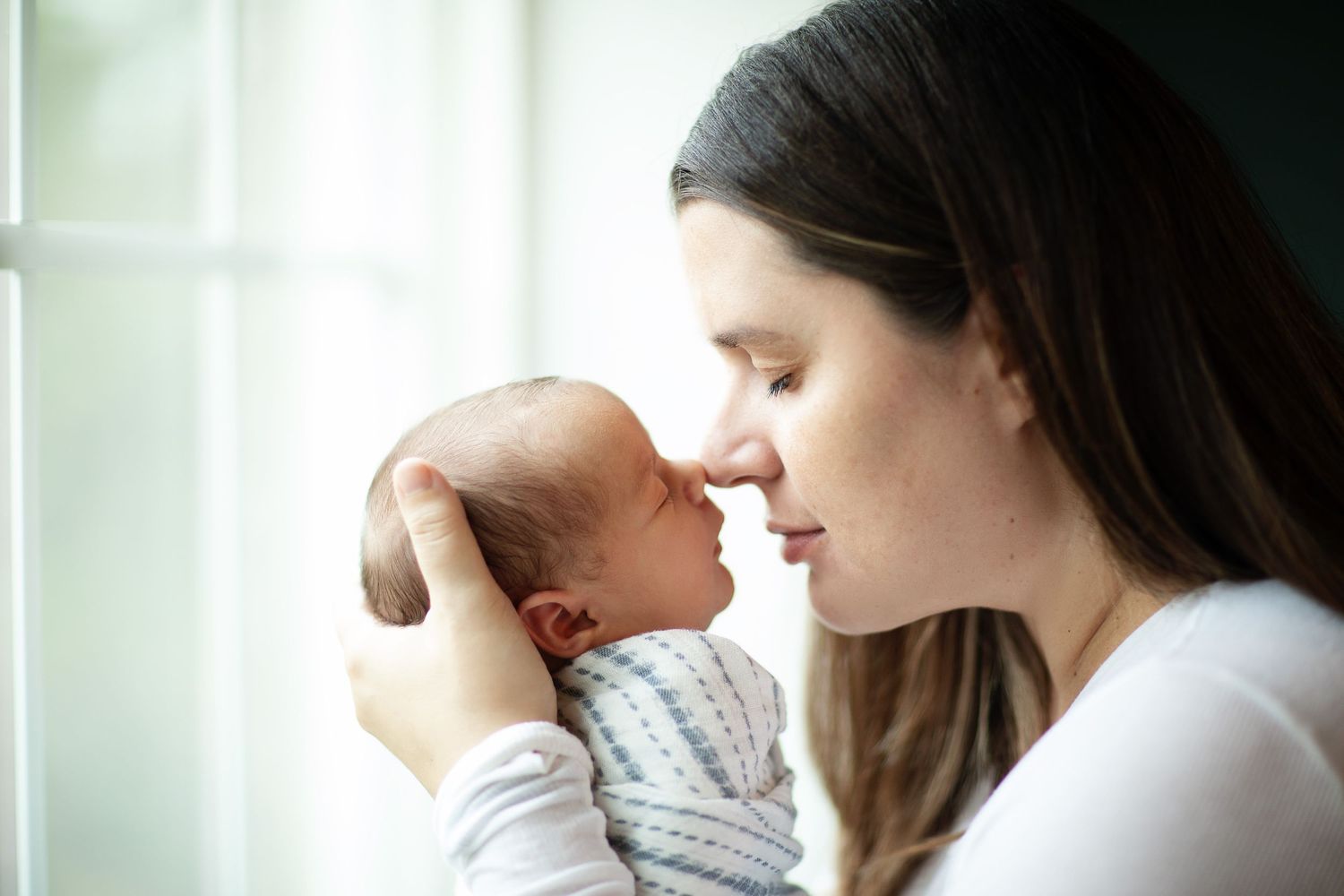 Tender indoor moment captured in soft natural window light.