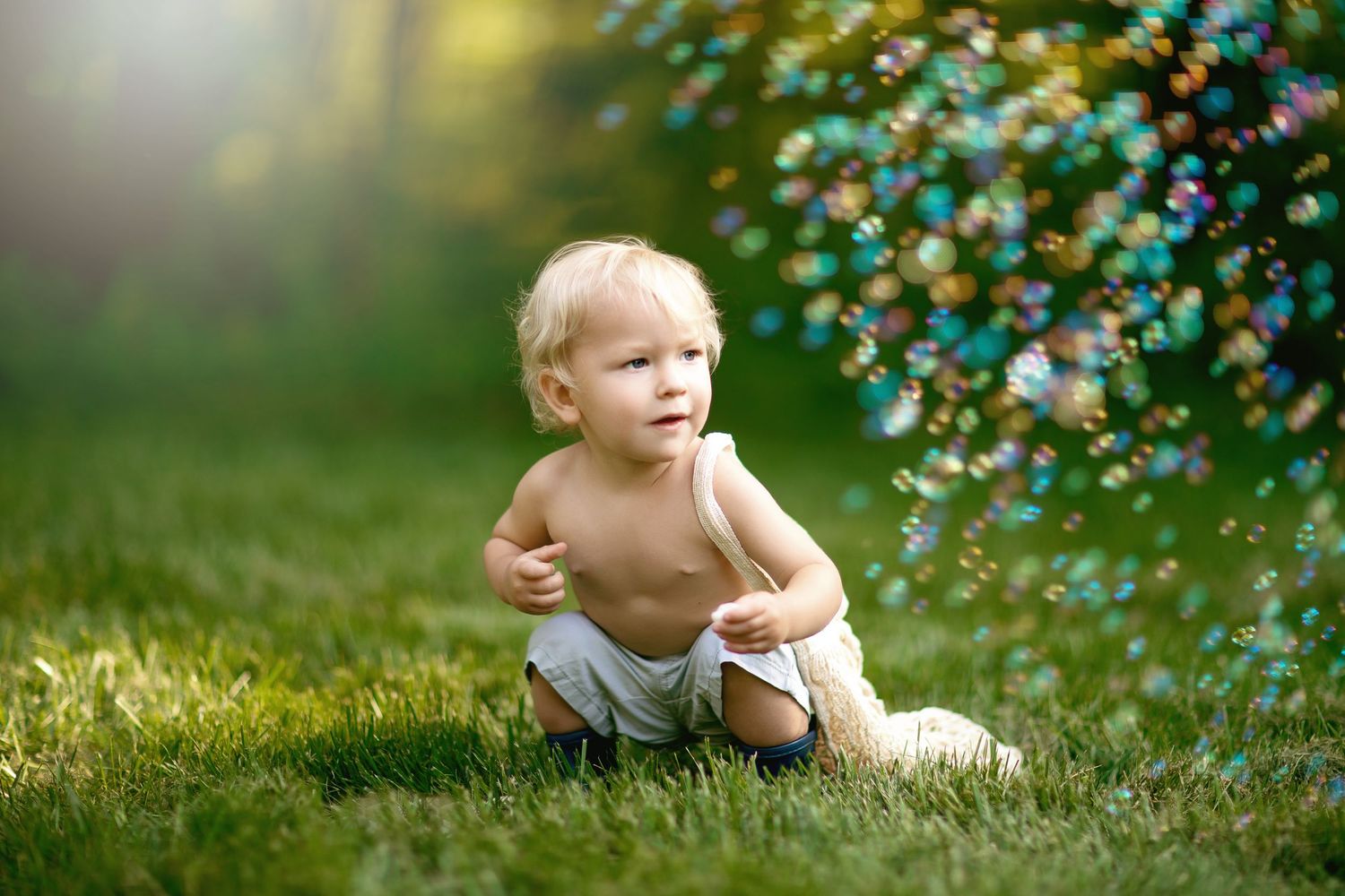 A child plays among sparkling bubbles in a sunlit garden.