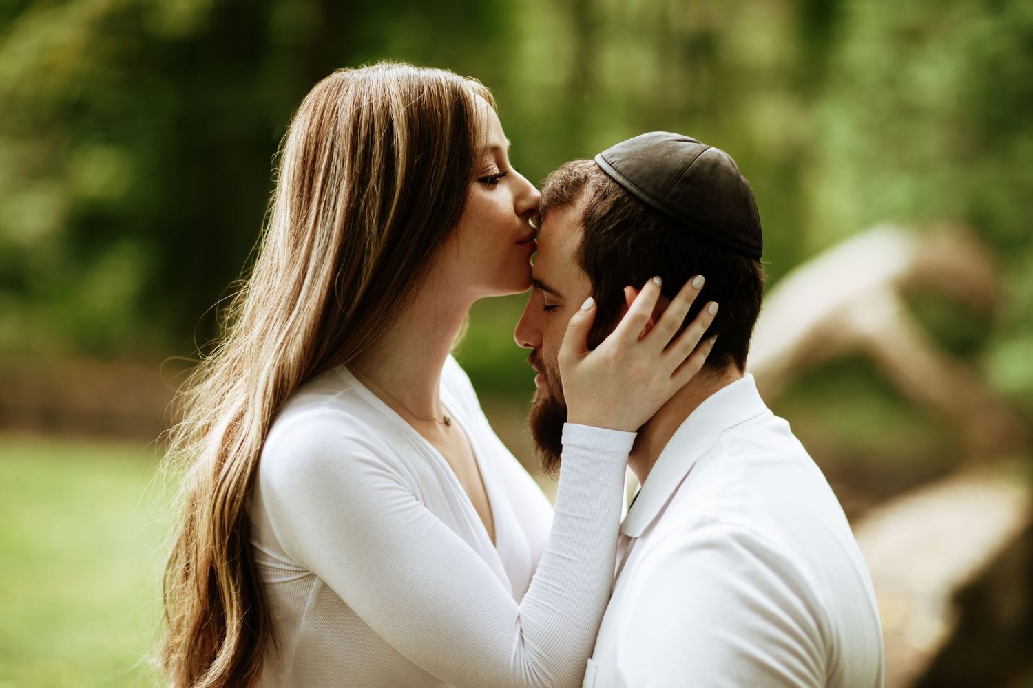Intimate couple's portrait session in lush green garden setting.