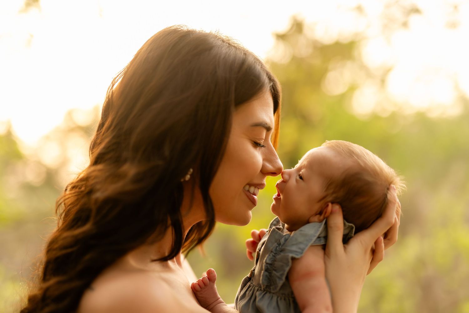 Tender family moment captured in golden sunlight during sunset.