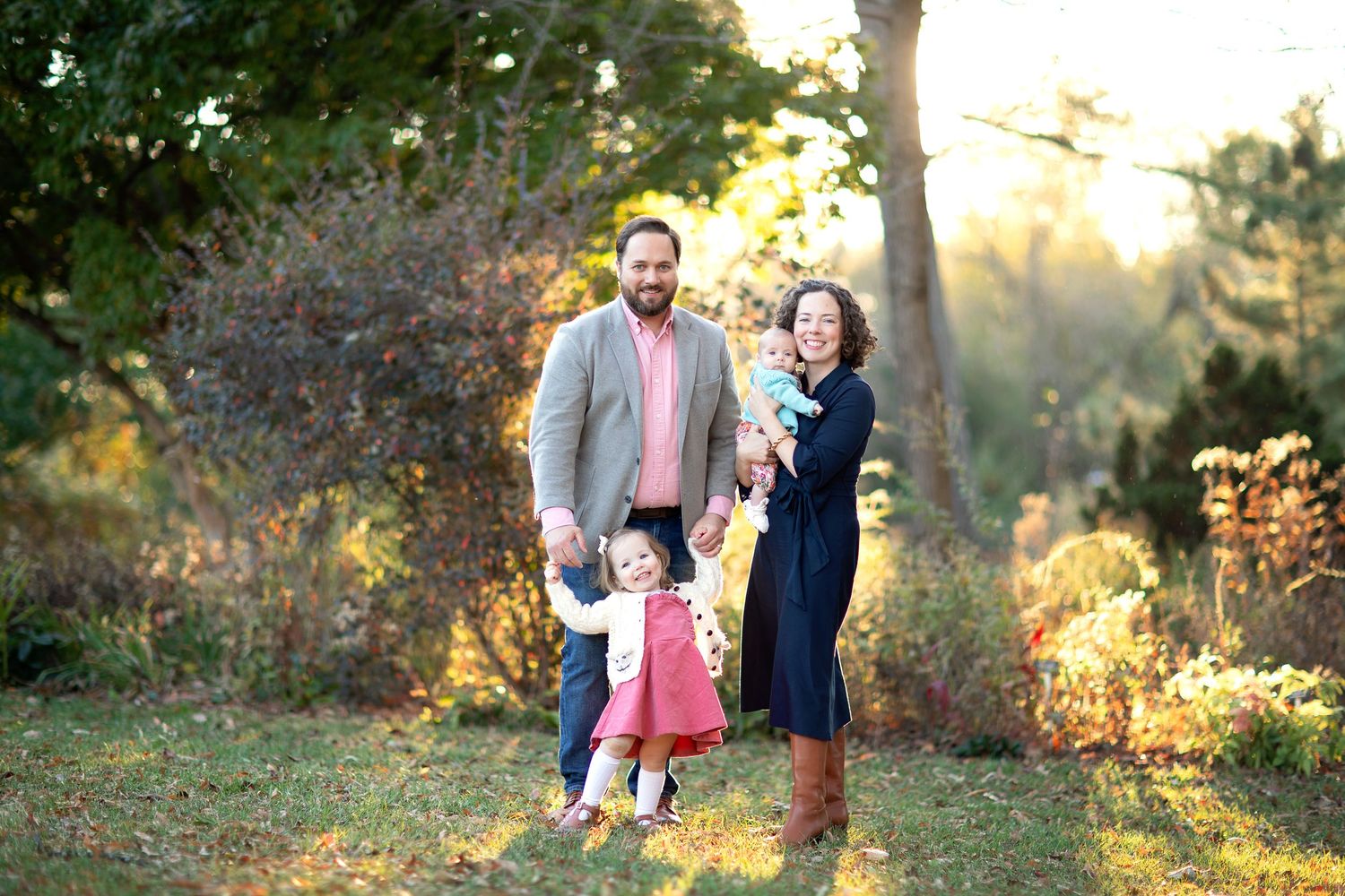 Family photoshoot in a natural outdoor setting during sunset.