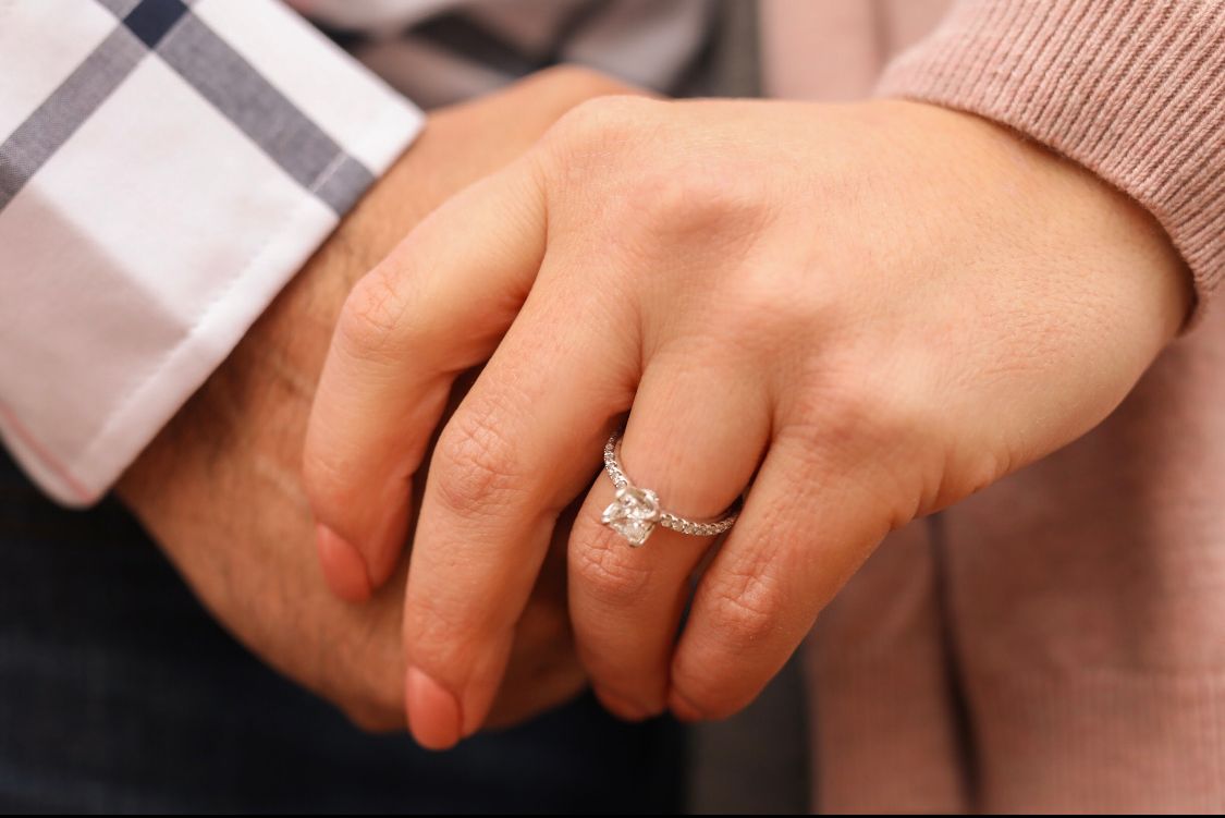 Detail shots of engagement ring and intertwined hands.
