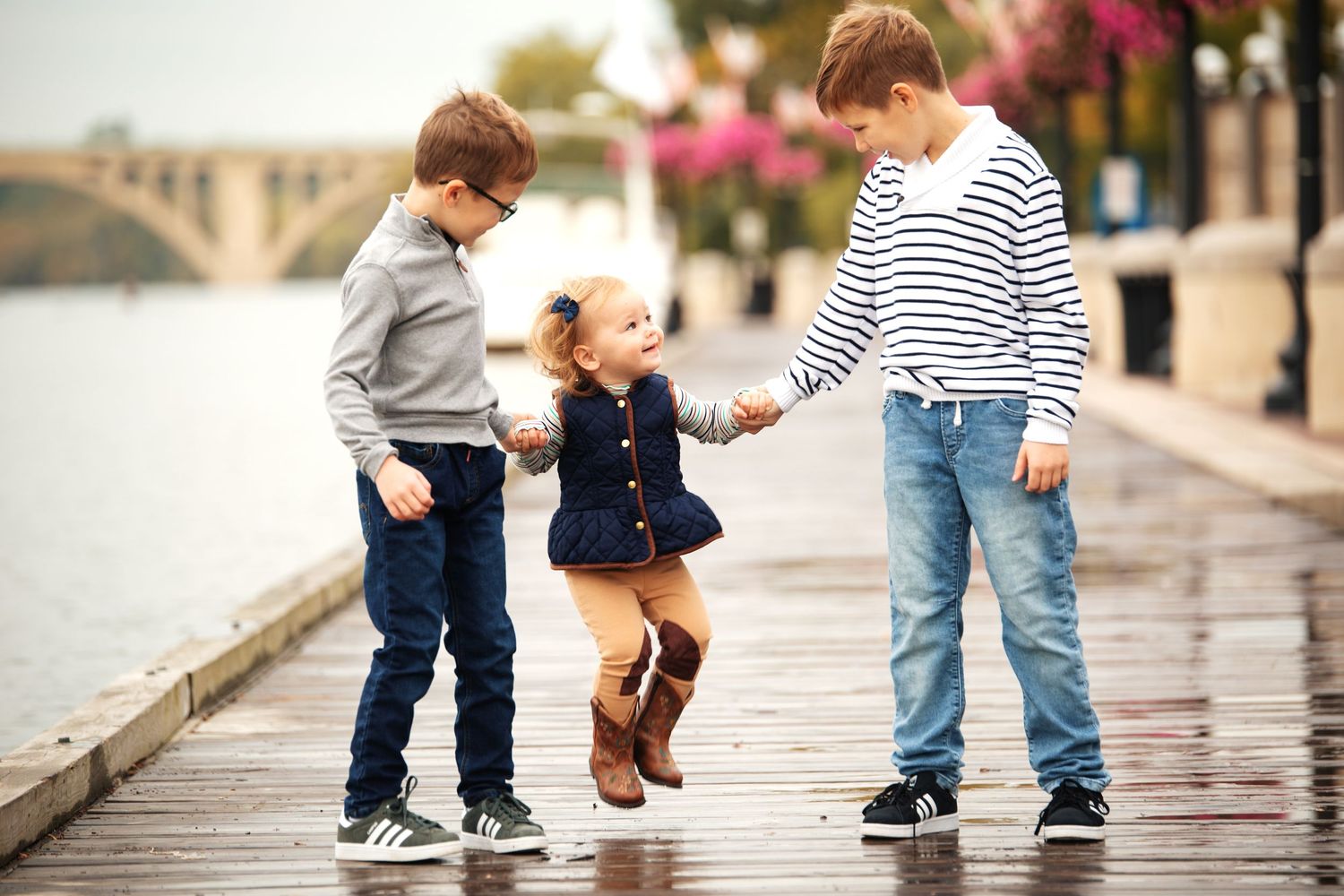 Small children's feet walking on wet pavement with stuffed animal.