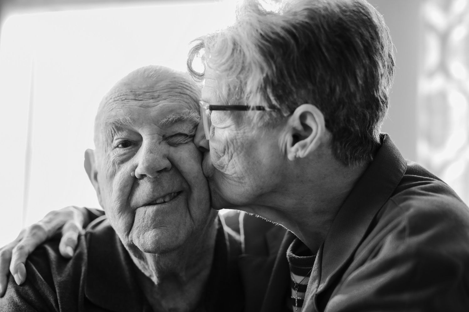 Black and white candid portraits showing joyful laughter and connection.