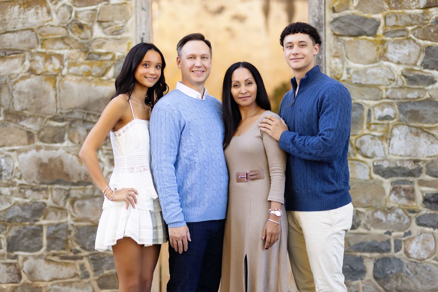Group photo against rustic stone wall backdrop during outdoor photography session.