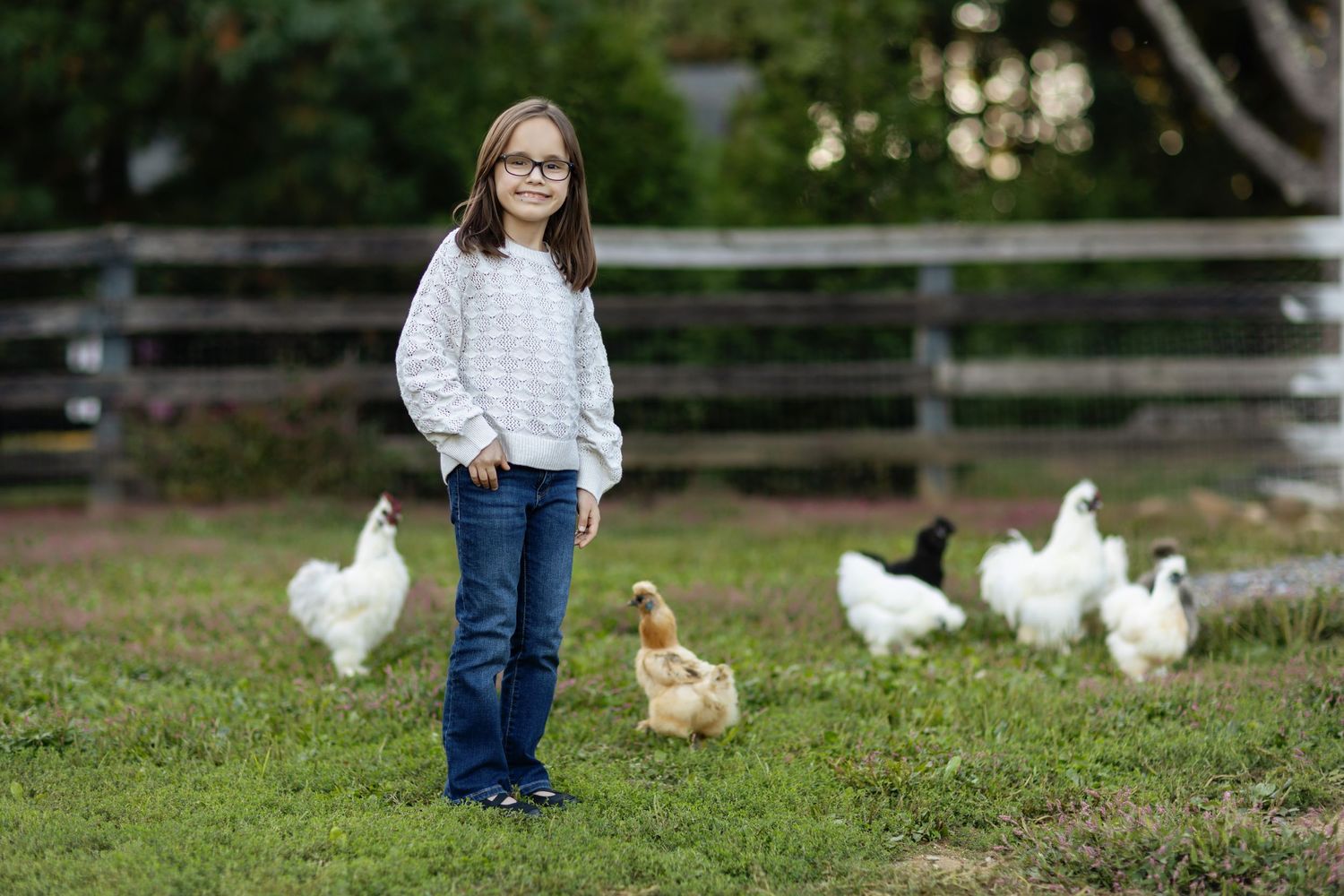 White ducks wandering in green grass during outdoor photoshoot.