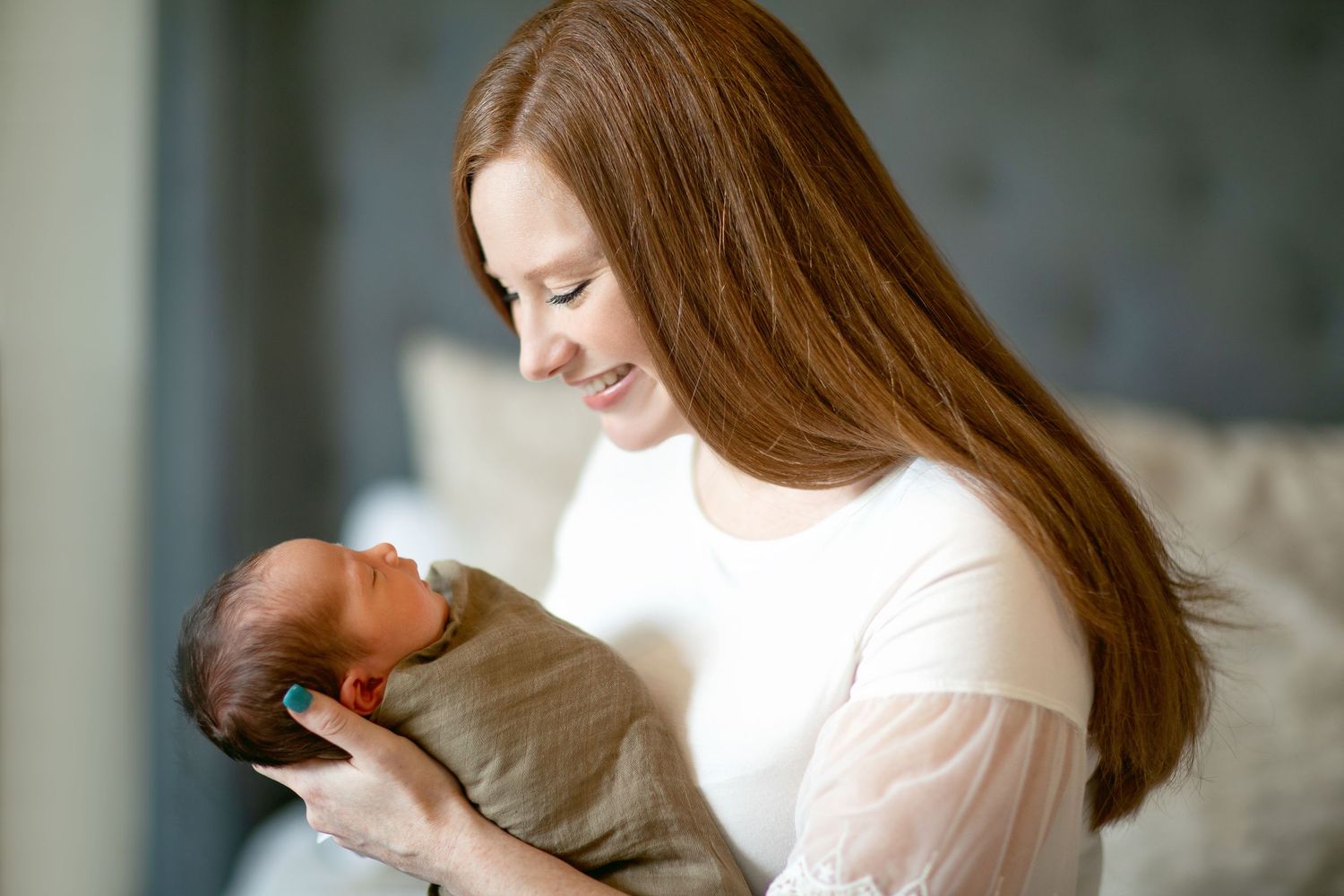 A tender moment between parent and newborn in soft natural light.