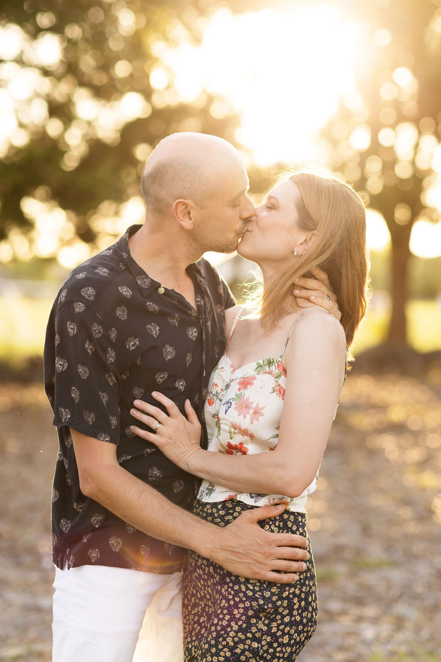 A romantic couple embraces during sunset for their engagement photos.