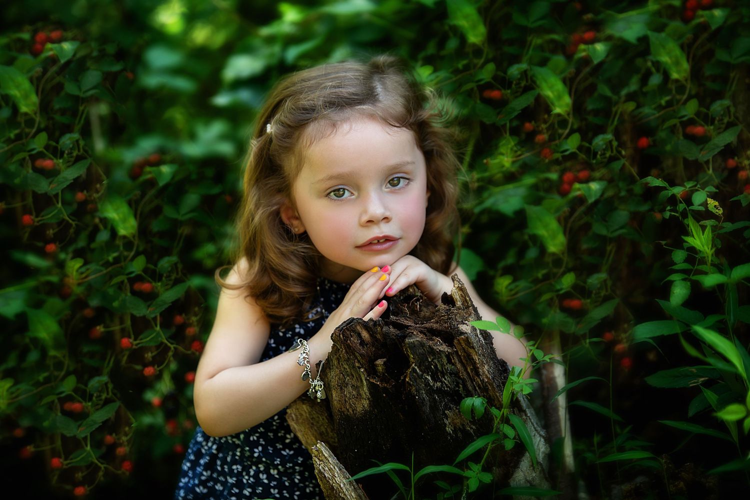 Children playing in a garden with red flowers and lush greenery.