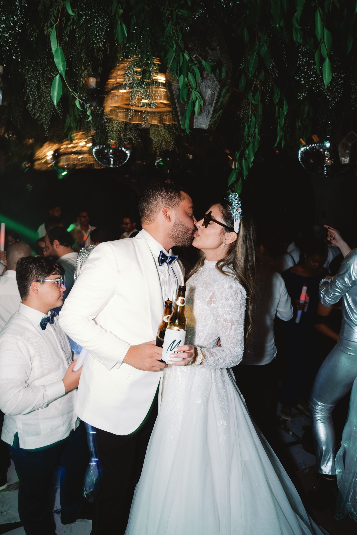 A sequence of wedding reception dance photos showing couples dancing together in a dimly lit venue with green decor.