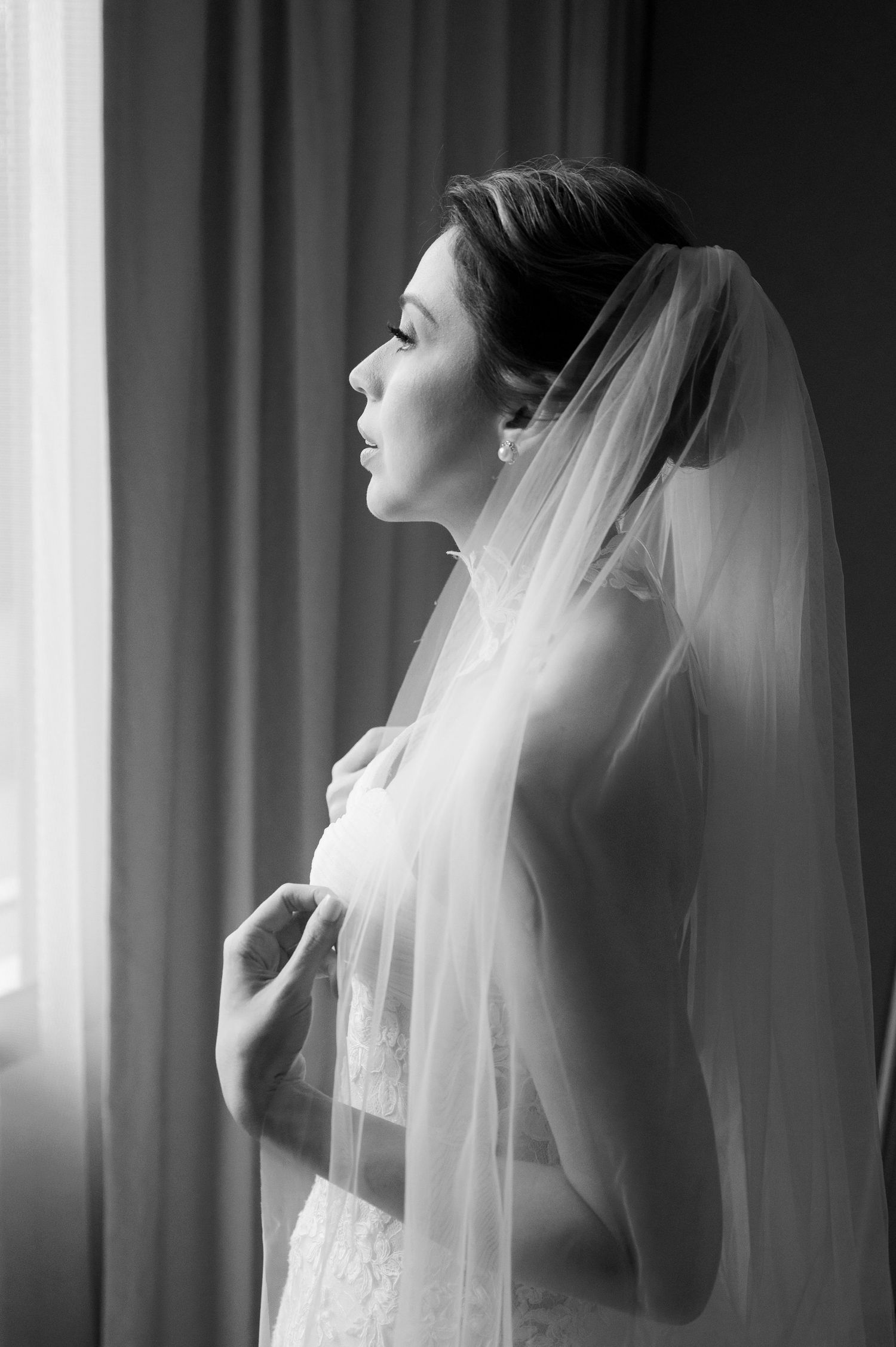 Artistic black and white series of a bride in her wedding veil captured in soft window light.