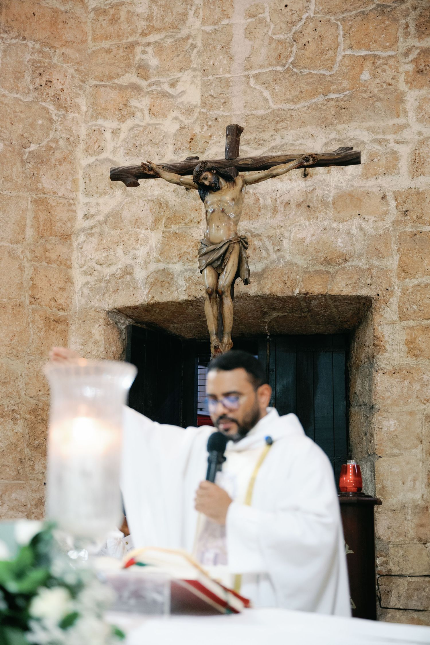 A series of photos showing a Catholic mass ceremony in a historic stone church with a crucifix visible.