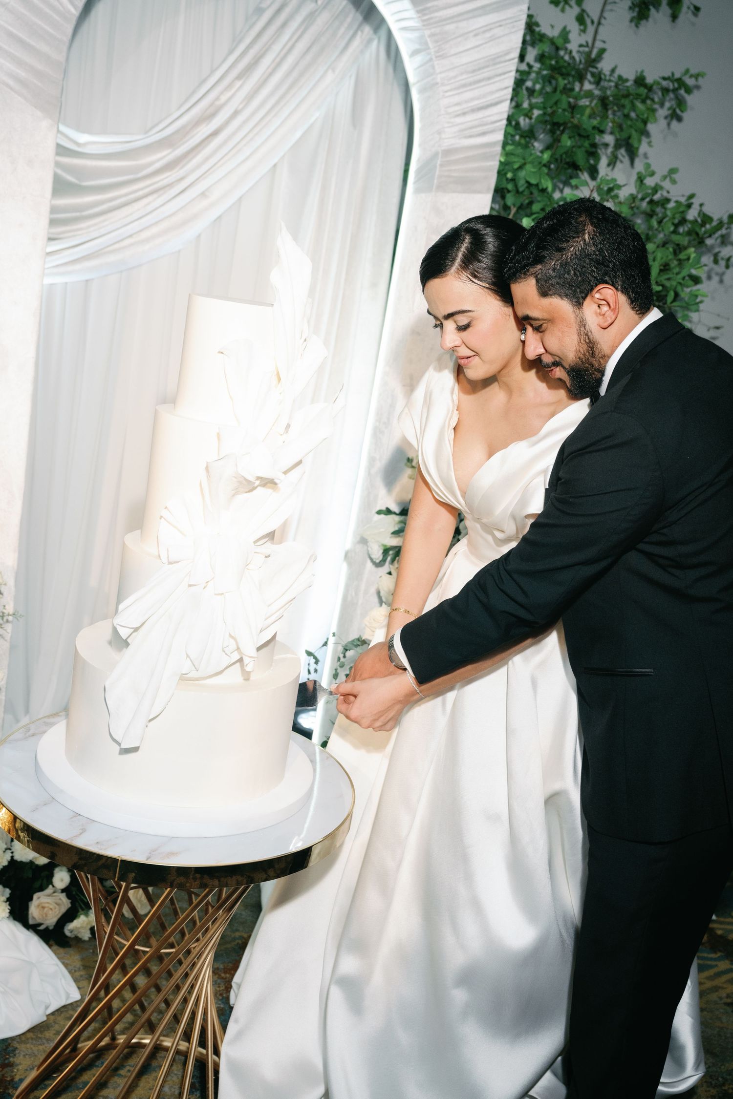 A romantic sequence of intimate dance poses between newlyweds against a white draped backdrop.